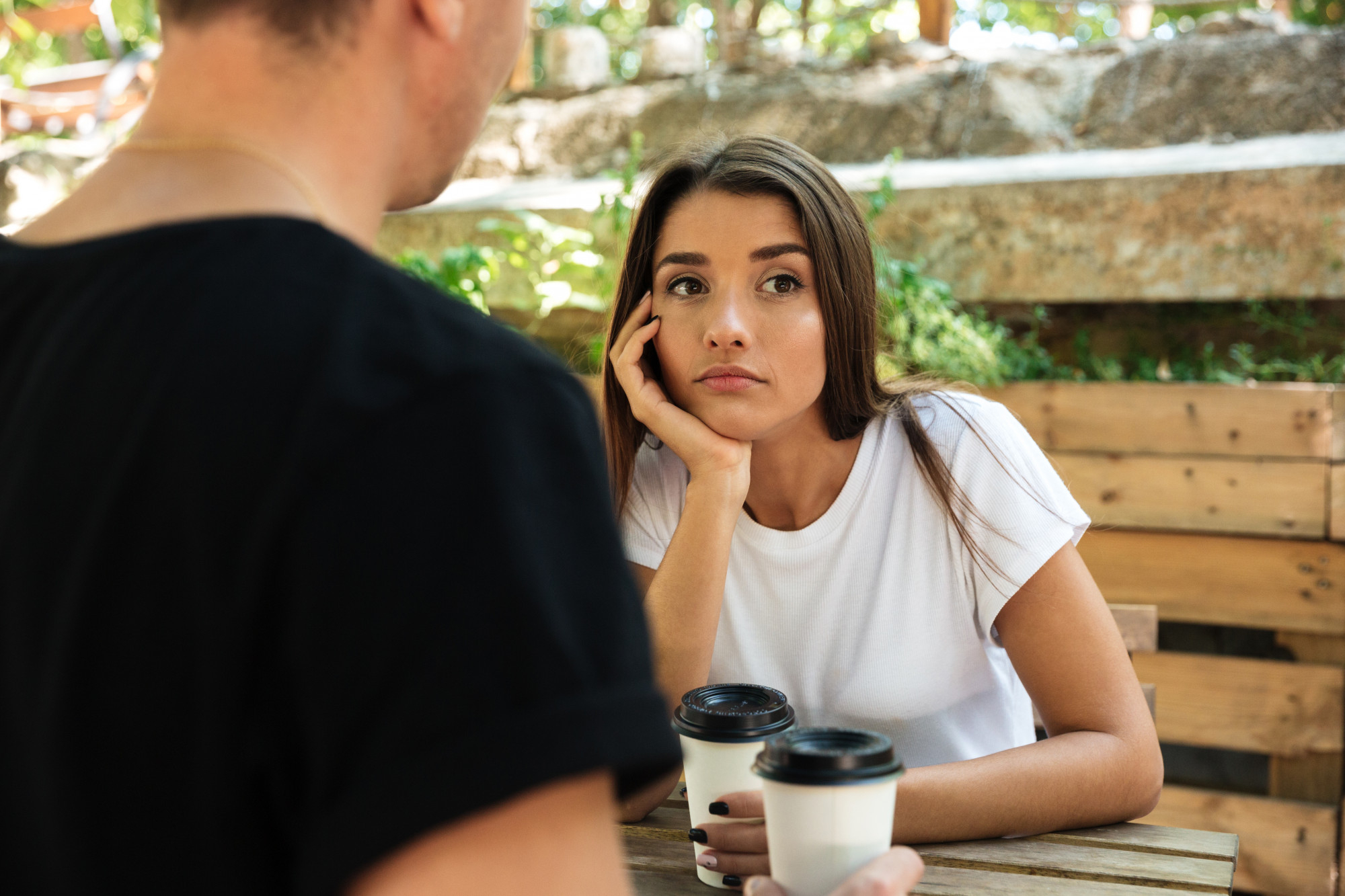 Una mujer de aspecto aburrido y molesto escucha hablar a un hombre | Fuente: Freepik