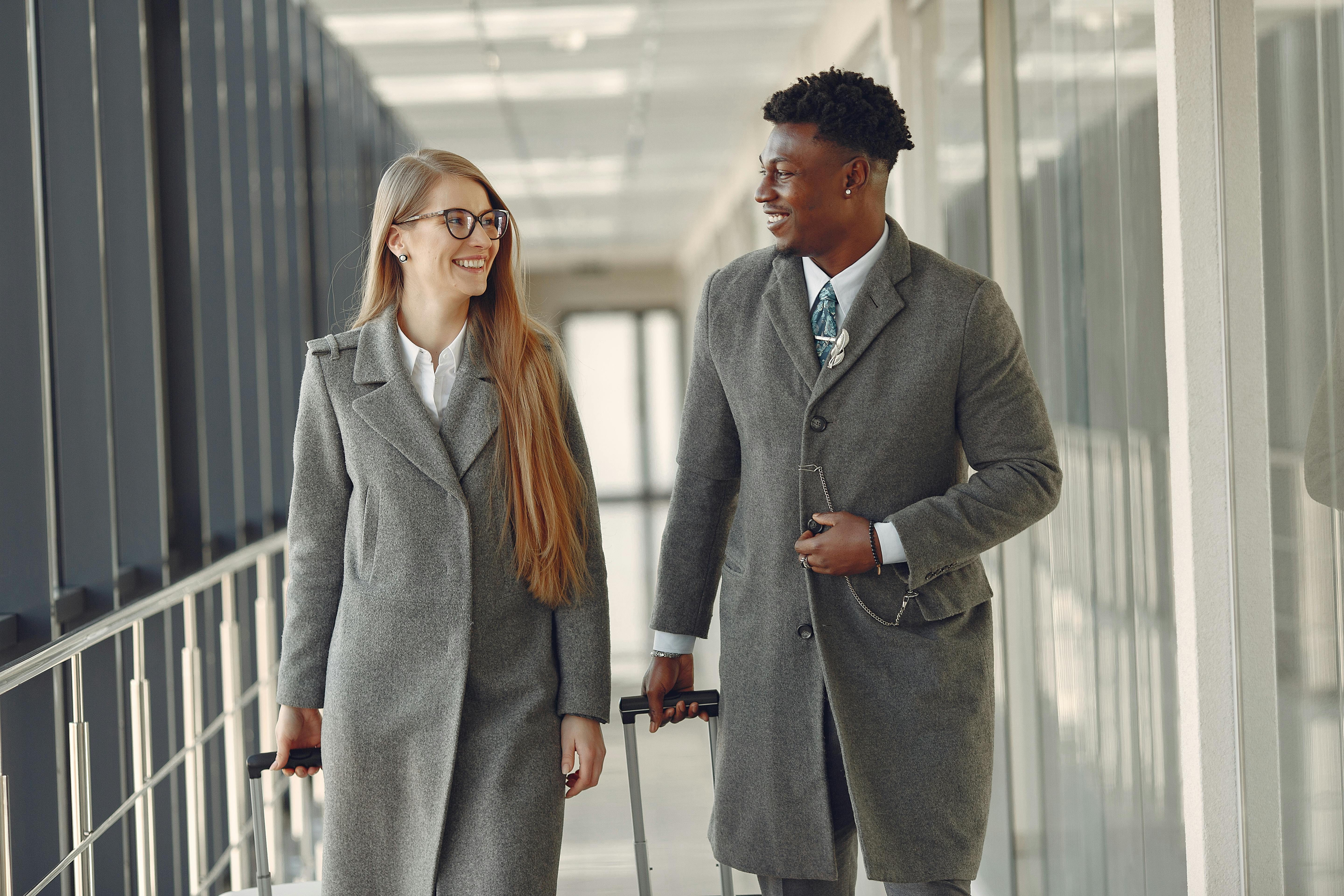 Una mujer y un hombre manteniendo una conversación en el pasillo de un aeropuerto | Fuente: Pexels