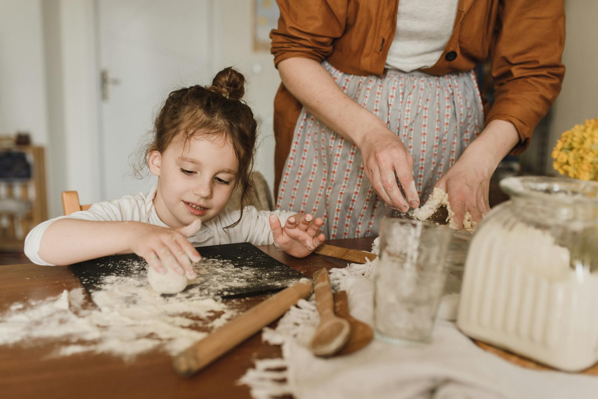 Una niña ayudando a su abuela a hornear | Fuente: Pexels