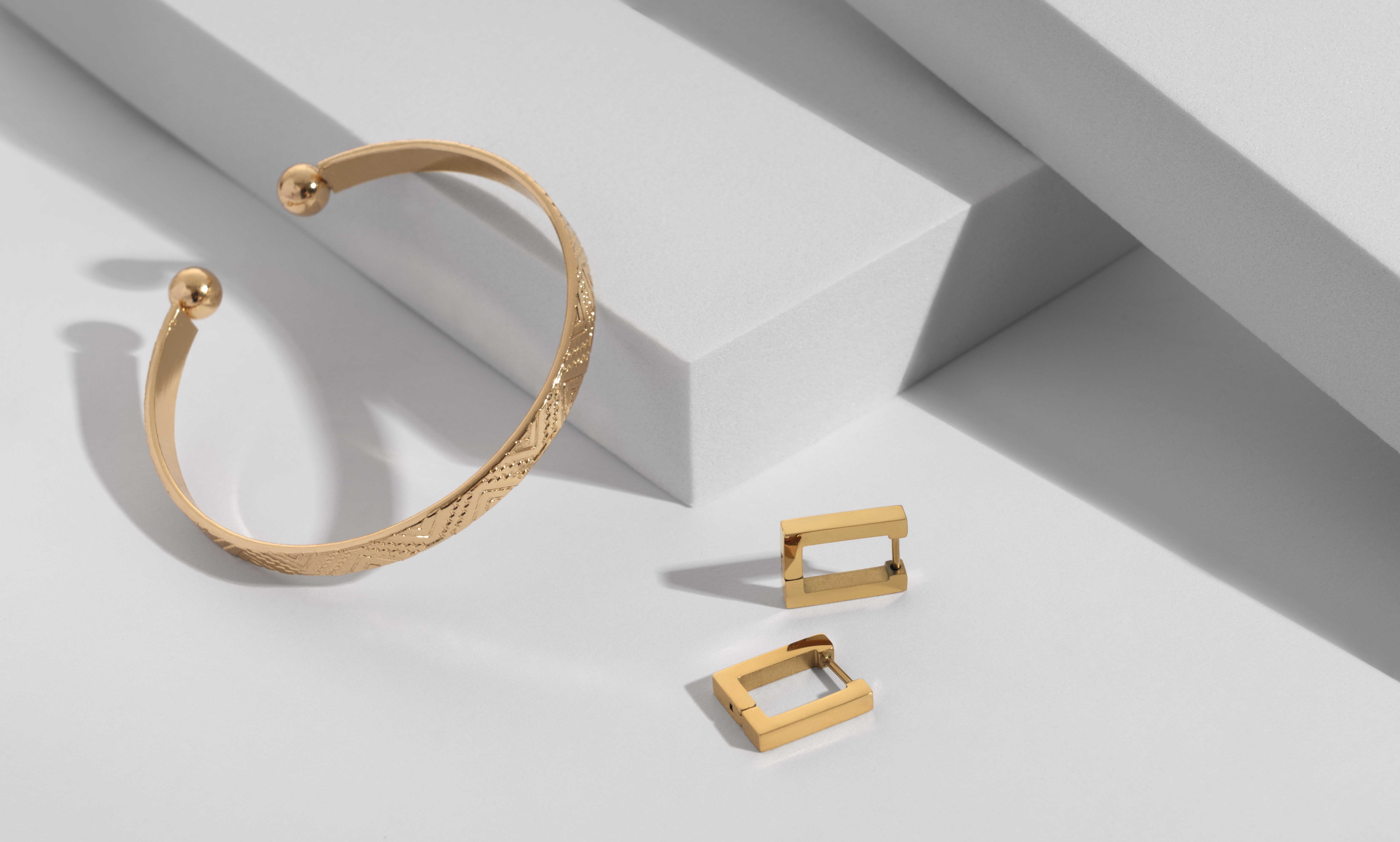 Un par de pendientes dorados y una pulsera. | Foto: Shutterstock