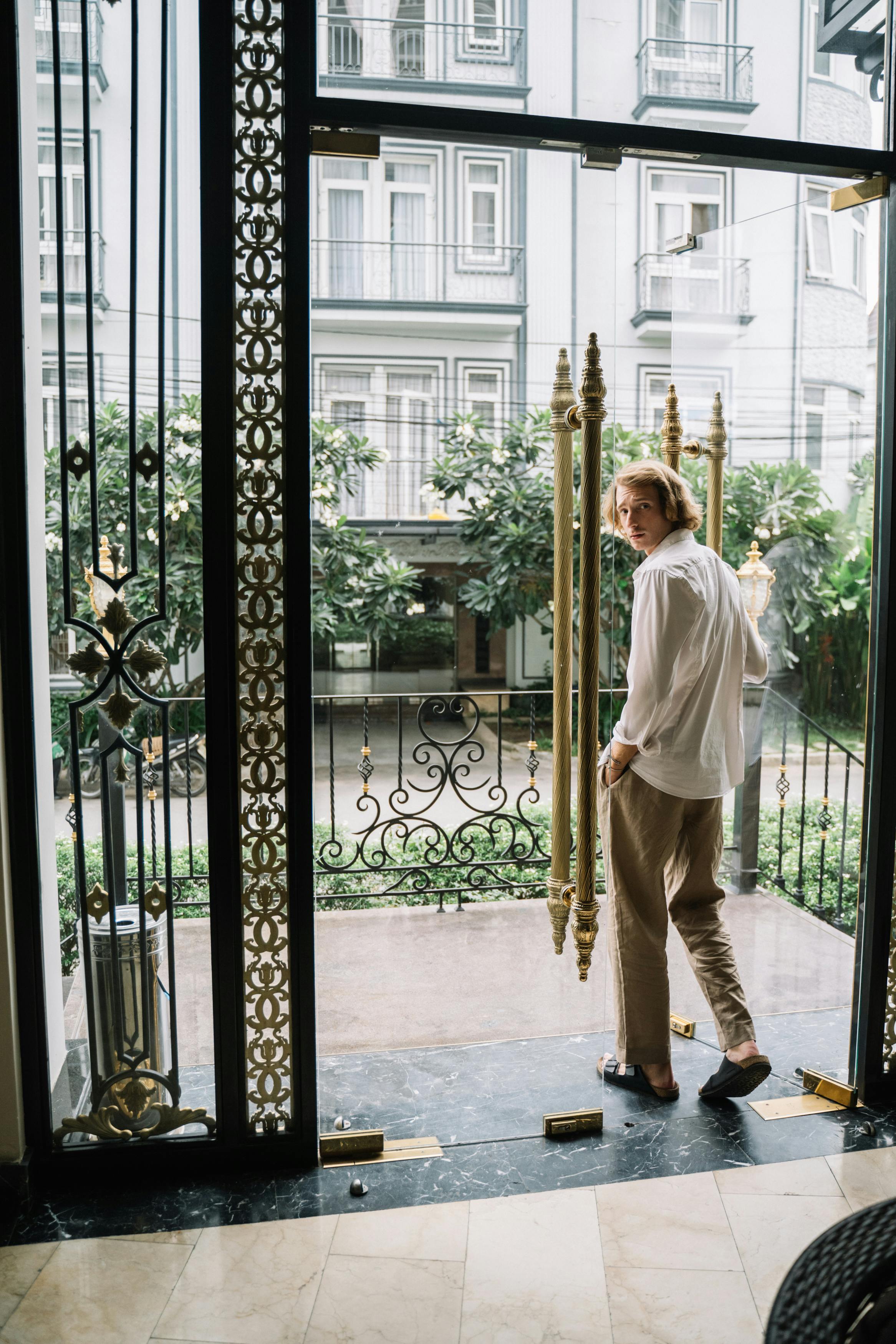 Un hombre mirando hacia atrás mientras atraviesa una puerta | Fuente: Pexels