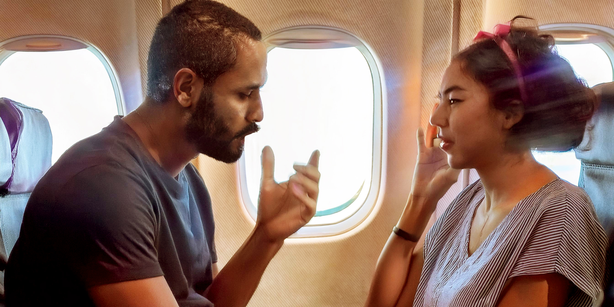 Un hombre y una mujer discutiendo en un avión | Fuente: AmoMama