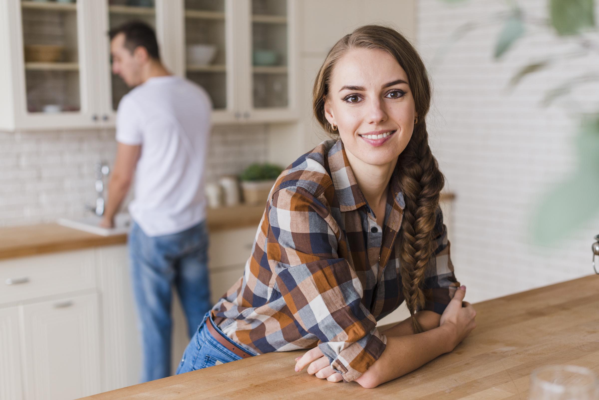 Mujer sonriente apoyada en la mesa | Fuente: Freepik