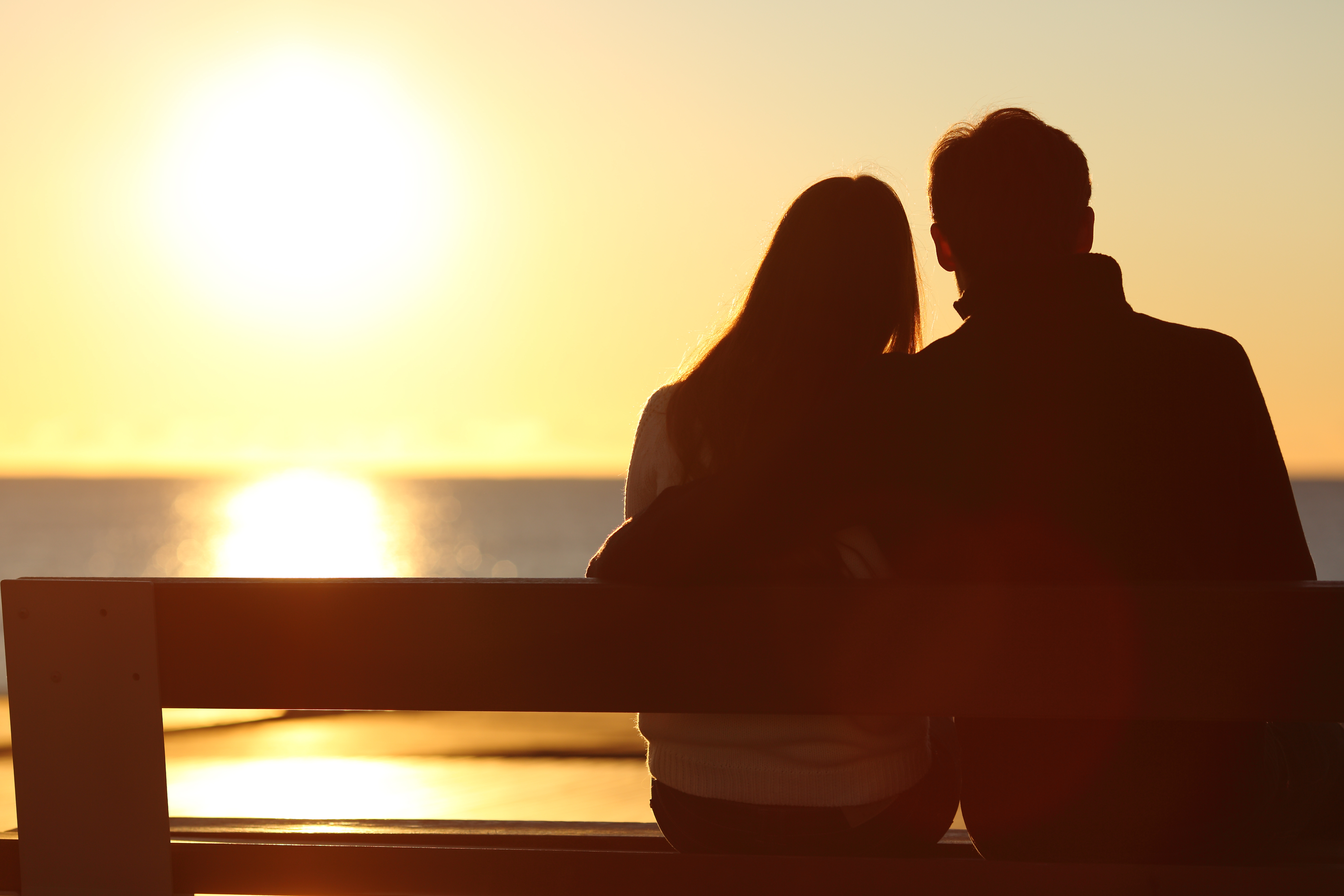 Silueta de una pareja mirando el sol en la playa | Foto: Shutterstock