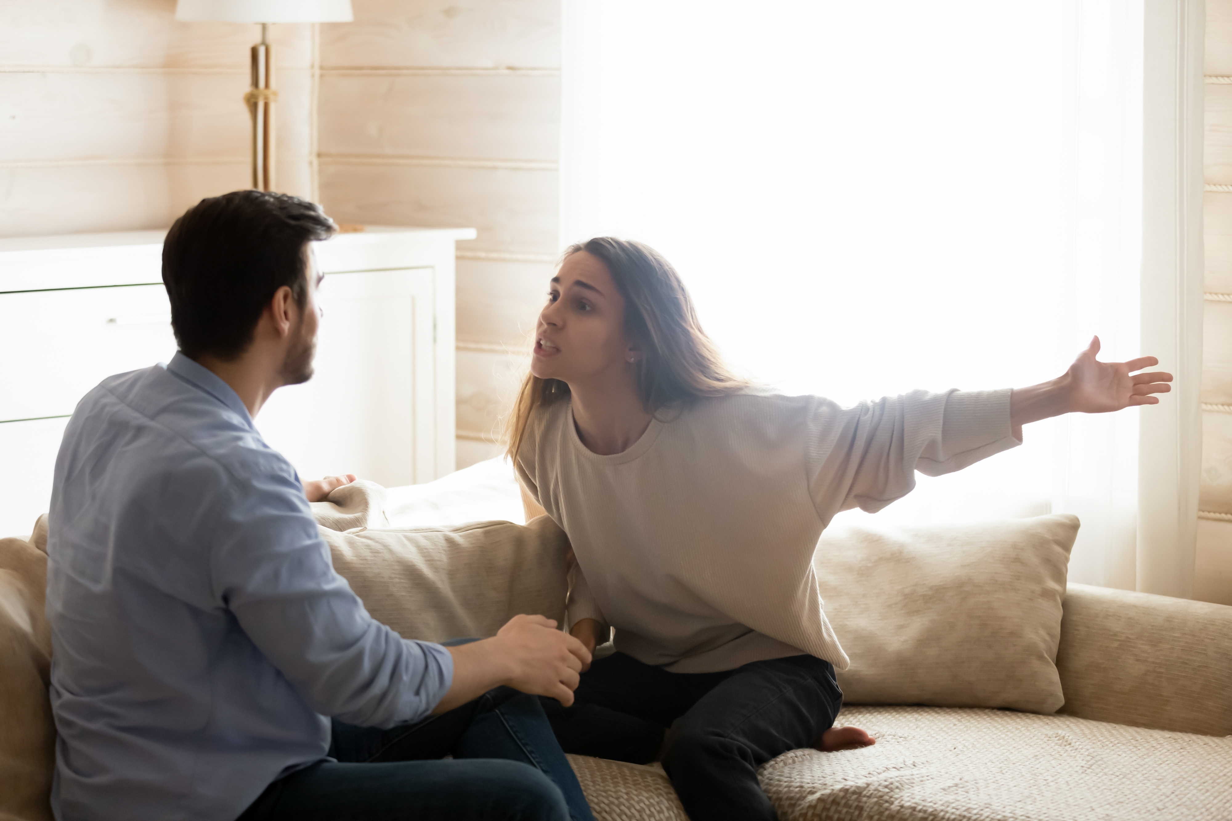 Malentendido. Jóvenes cónyuges enfadados y preocupados discutiendo en casa. | Fuente: Shutterstock