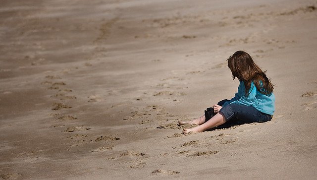 Joven sentada en la playa. | Foto: Flickr