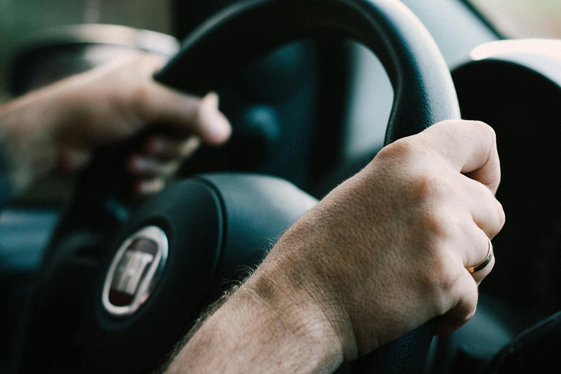 Primer plano de las manos de un hombre sobre un volante | Fuente: Pexels