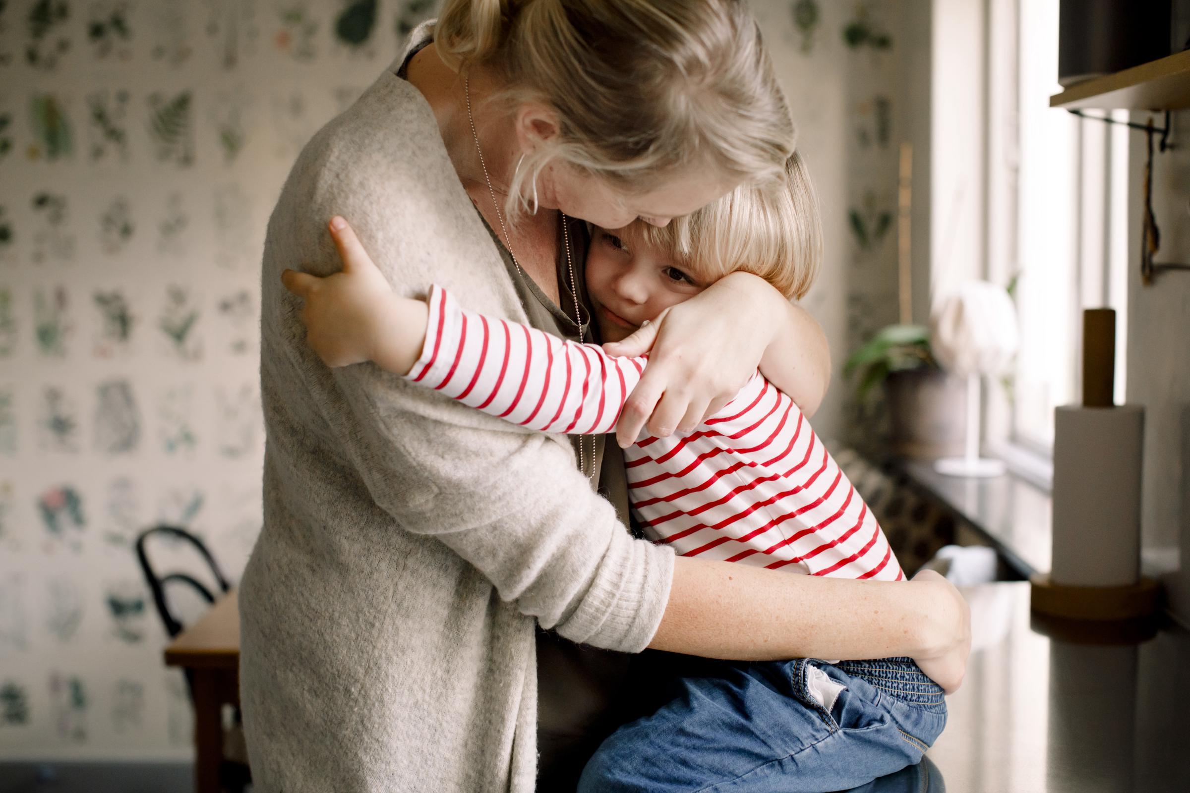Una madre abrazando a su hija en su cocina | Fuente: Getty Images