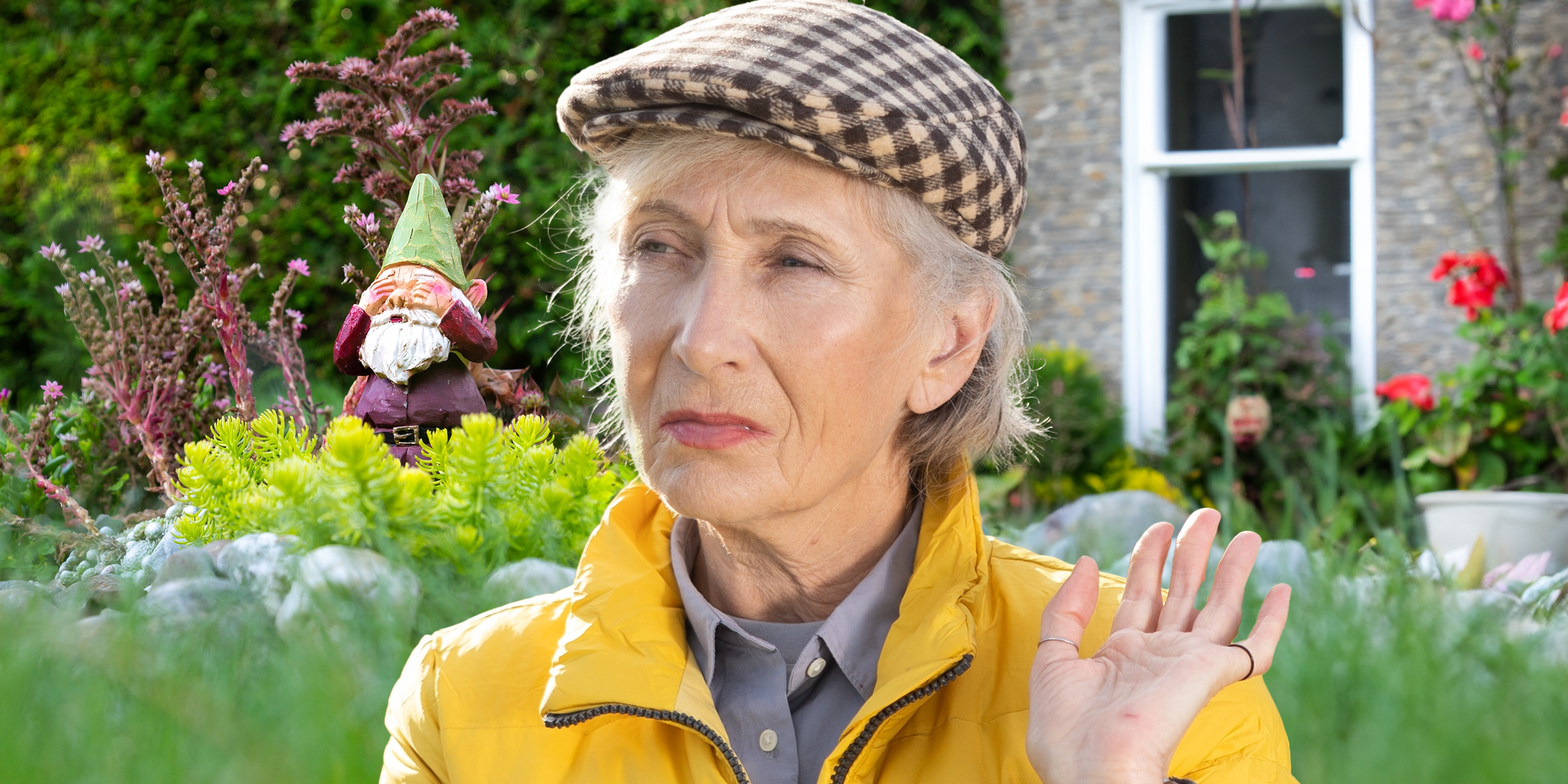 Una mujer mayor con un gnomo de jardín de fondo | Fuente: Shutterstock