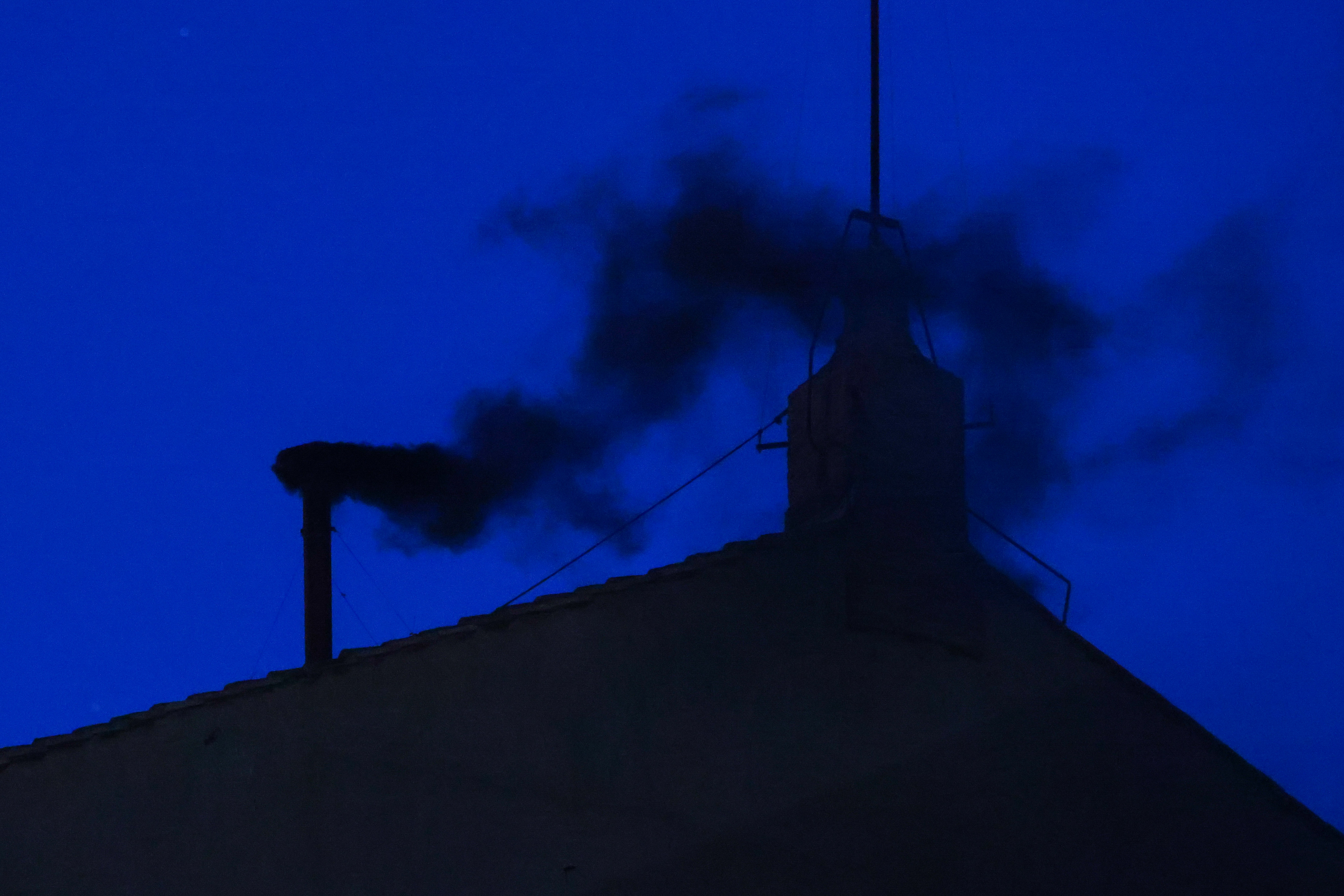 Sale humo negro de la chimenea de la Capilla Sixtina en la Ciudad del Vaticano, el 7 de mayo de 2025 | Fuente: Getty Images
