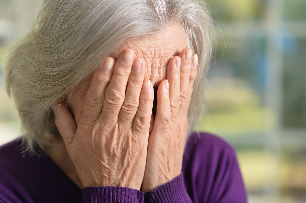 Mujer se cubre la cara mientras llora | Fuente: Shutterstock