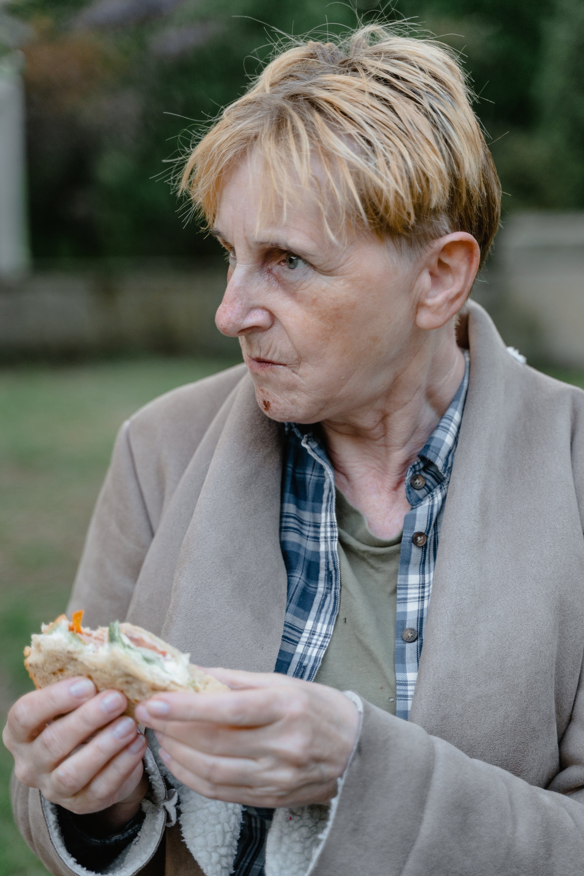 Una mujer mayor con un bocadillo en la mano | Fuente: Pexels