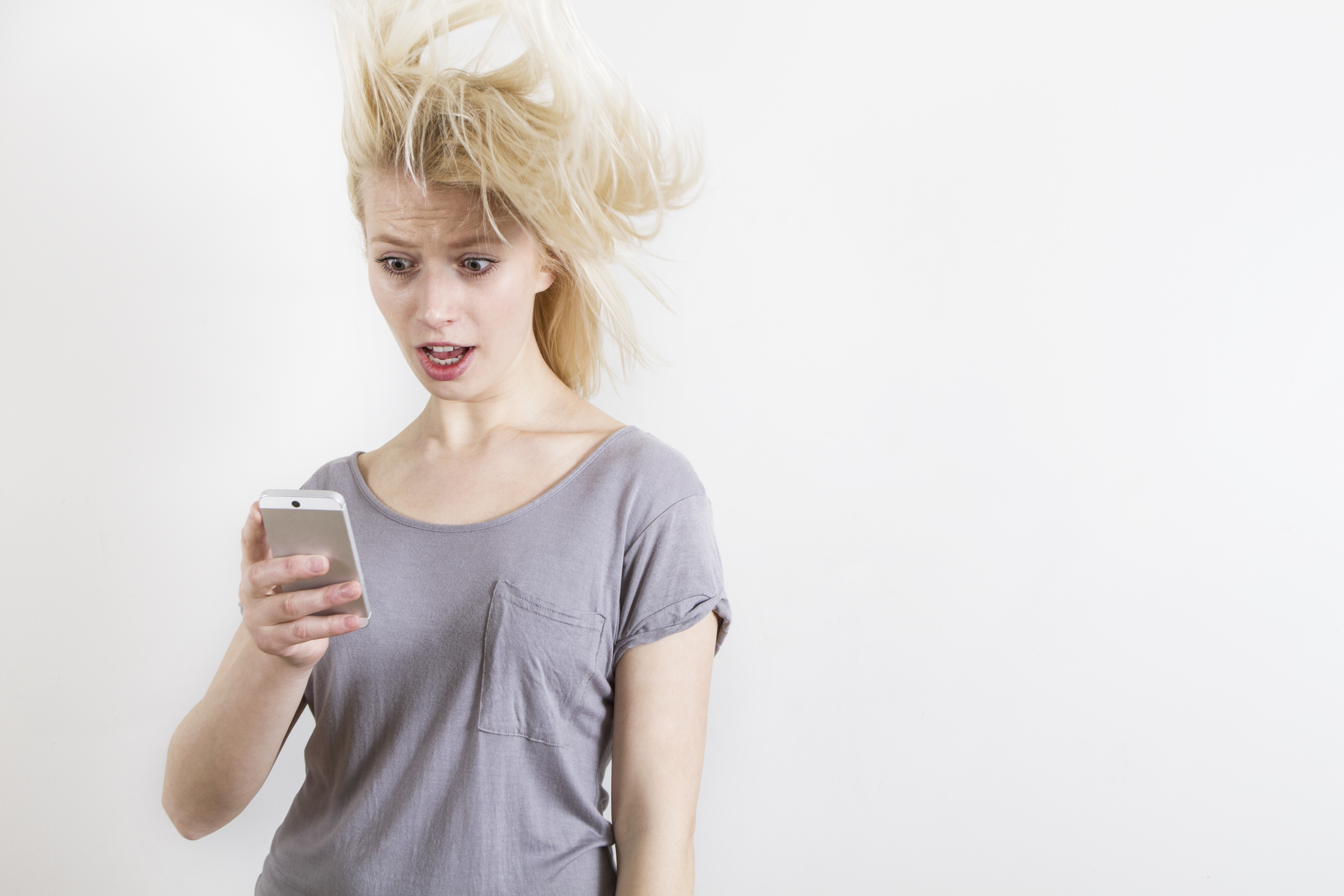 Mujer con expresión de sorpresa mirando el teléfono | Foto: Getty Images
