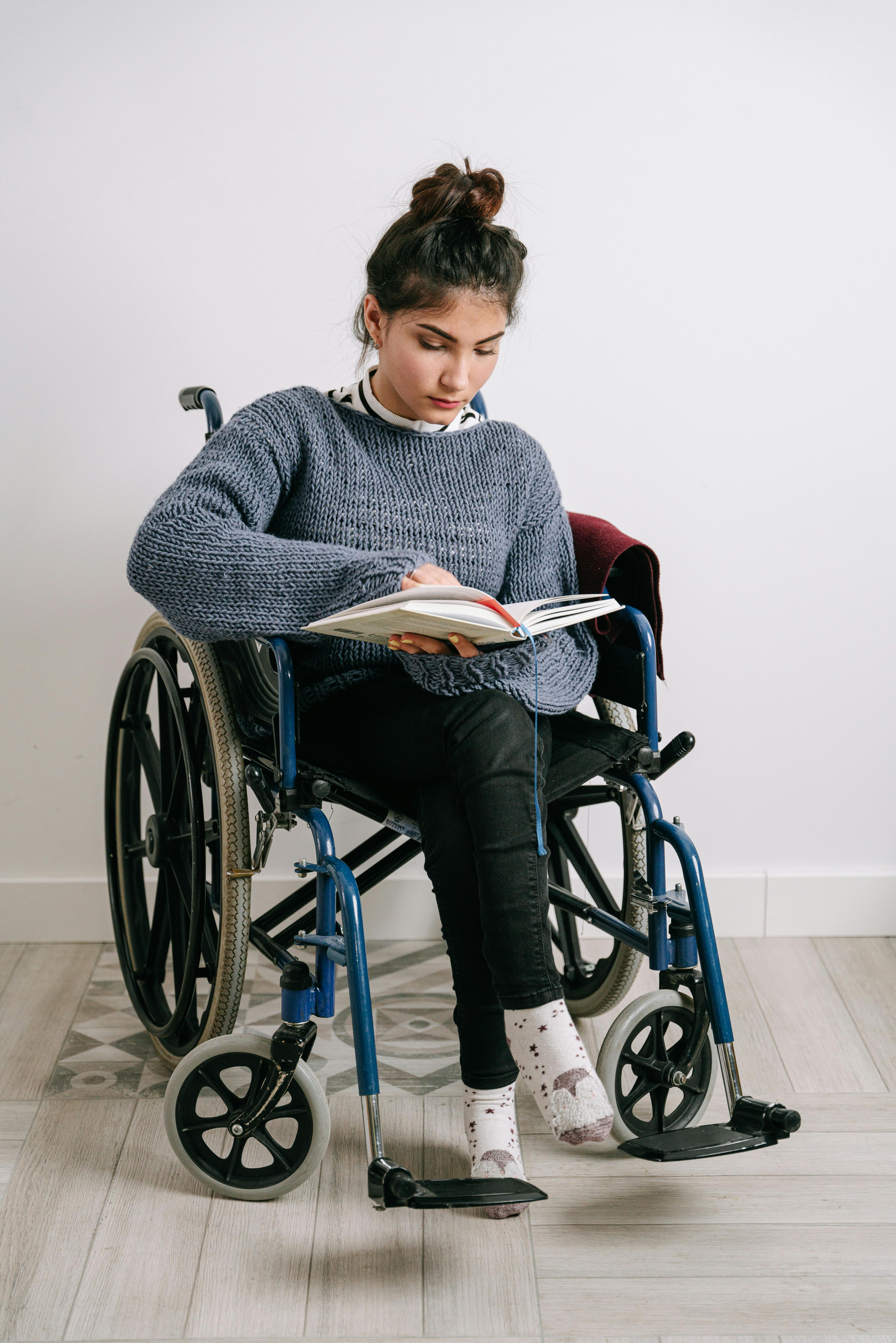 Una joven en silla de ruedas leyendo. | Imagen con fines ilustrativos | Fuente: Pexels