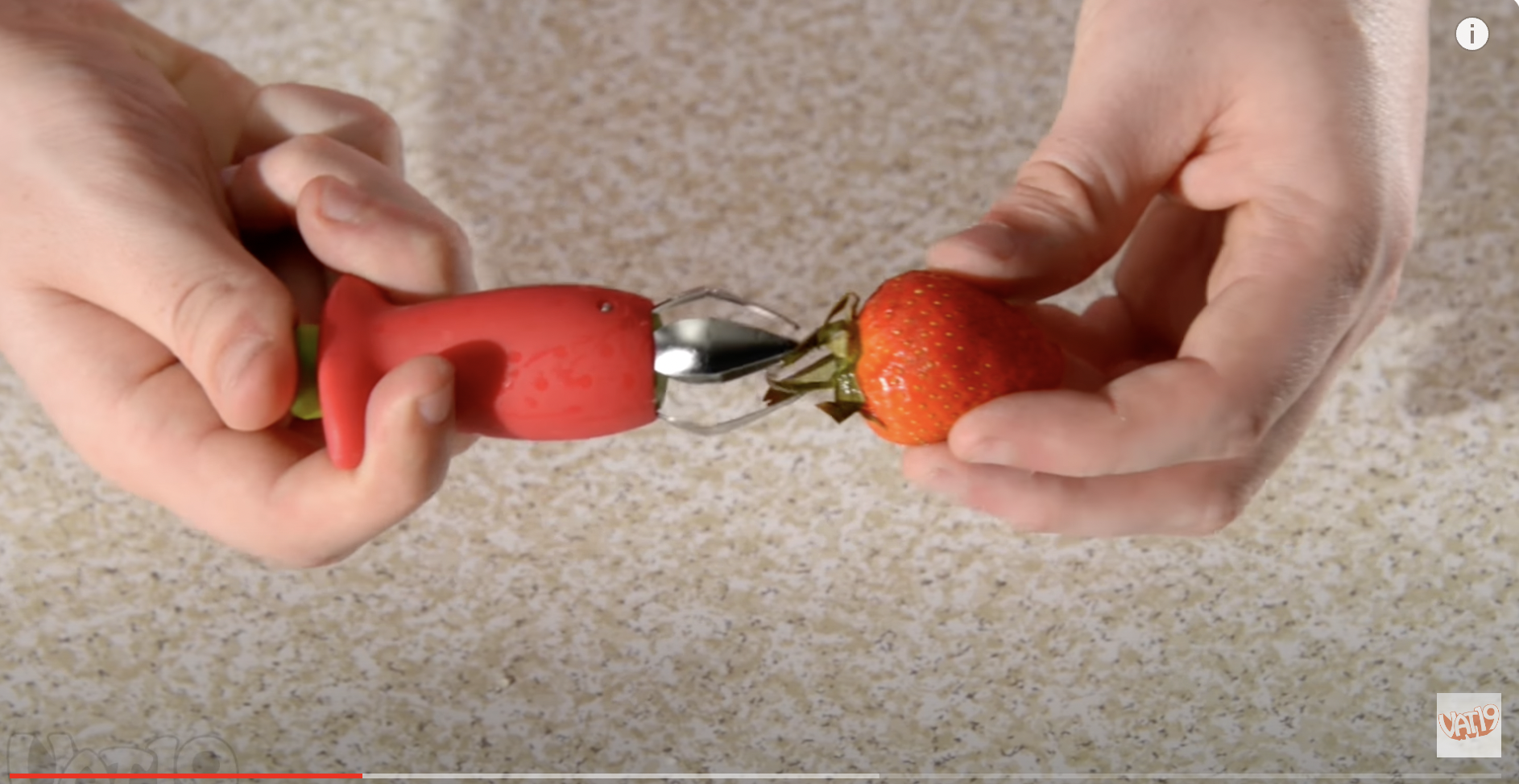 Un descorazonador retirando el tallo de una fresa. | Fuente: Youtube/Vat19