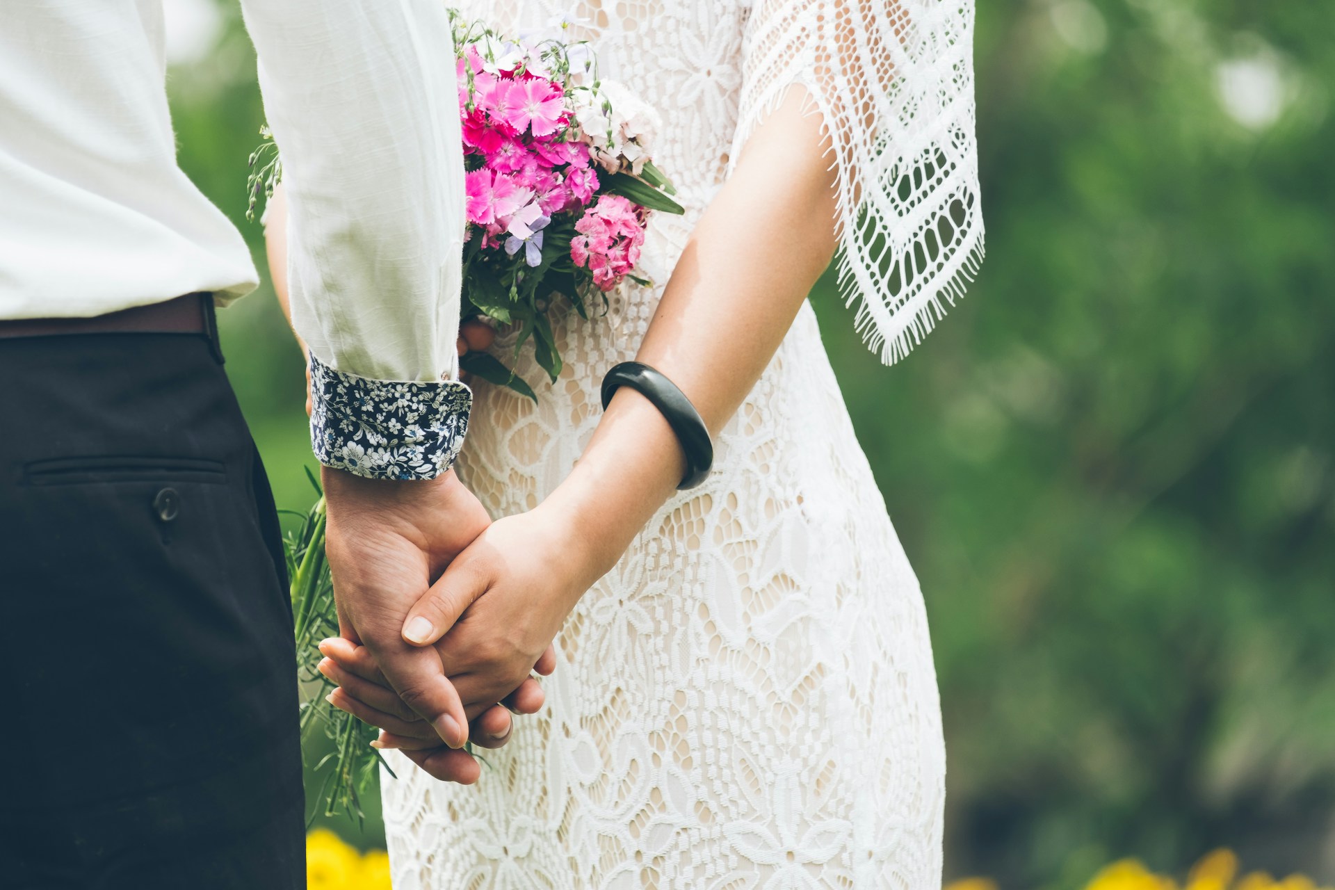 Una pareja de recién casados tomados de la mano | Fuente: Unsplash