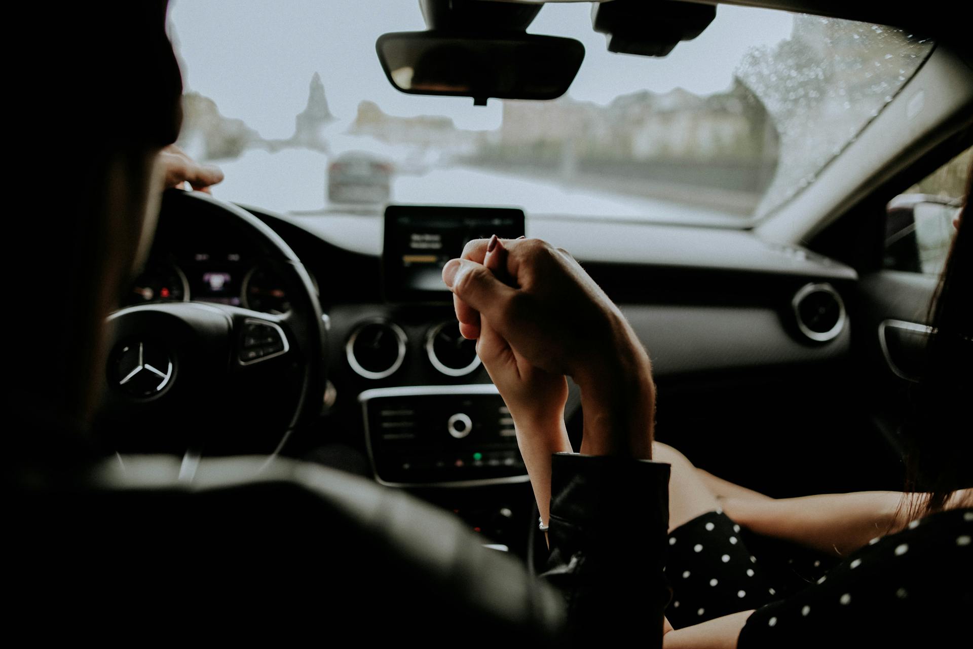 Una pareja cogida de la mano en el interior de un Automóvil | Fuente: Pexels