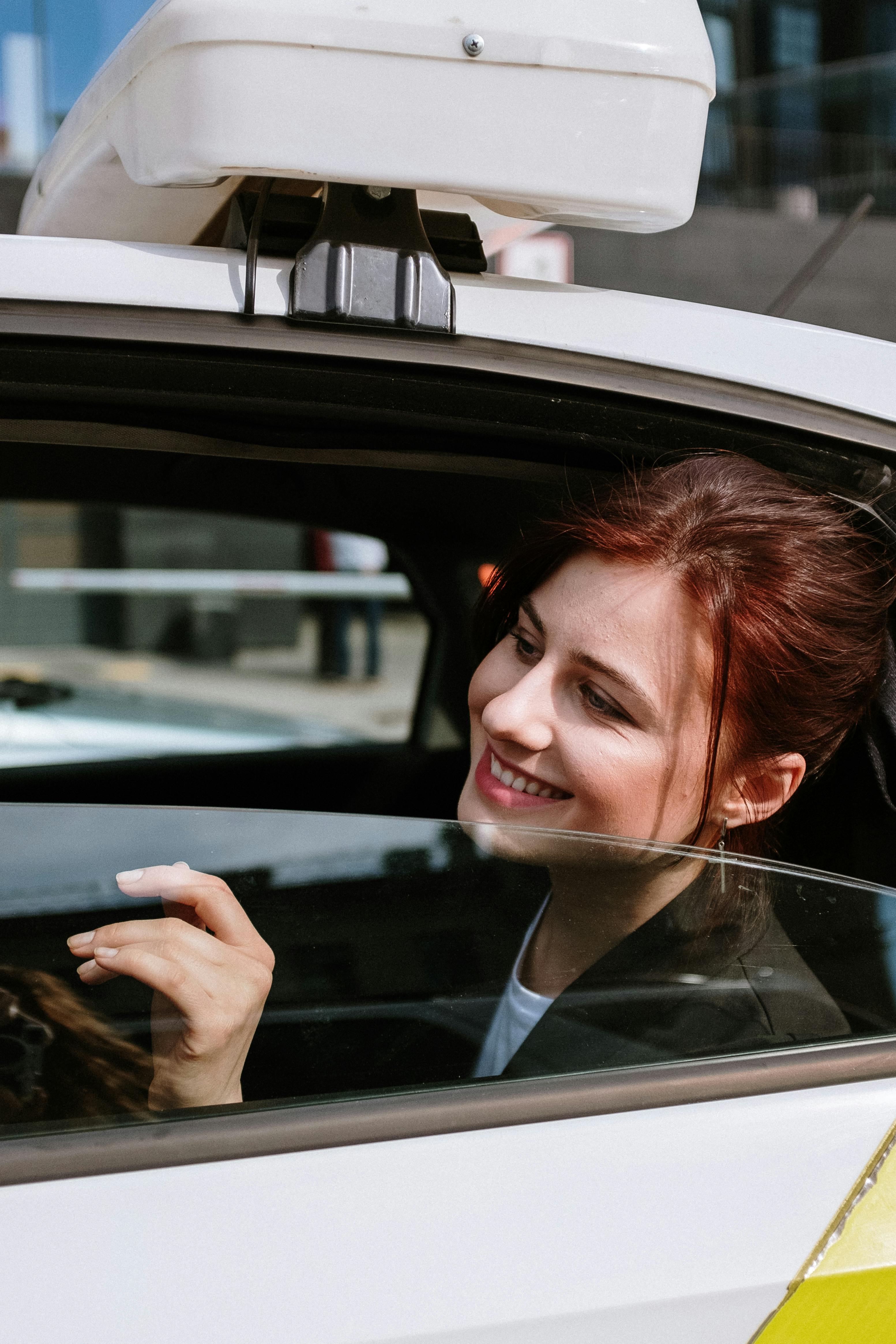 Una mujer sonriente mirando por la ventanilla de un Automóvil | Fuente: Pexels