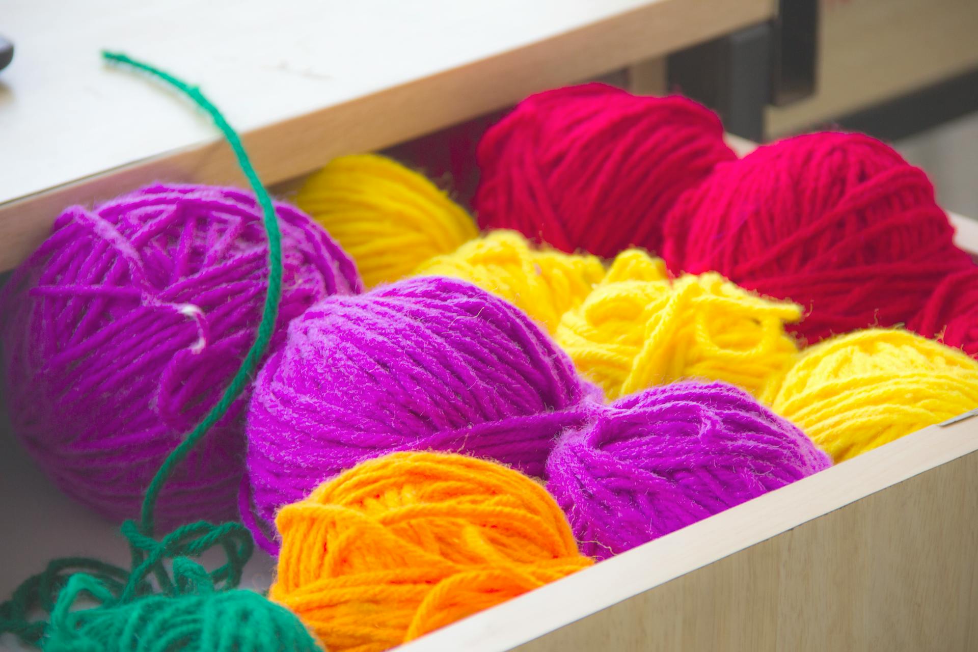 Coloridos ovillos de hilo en un cajón | Fuente: Pexels