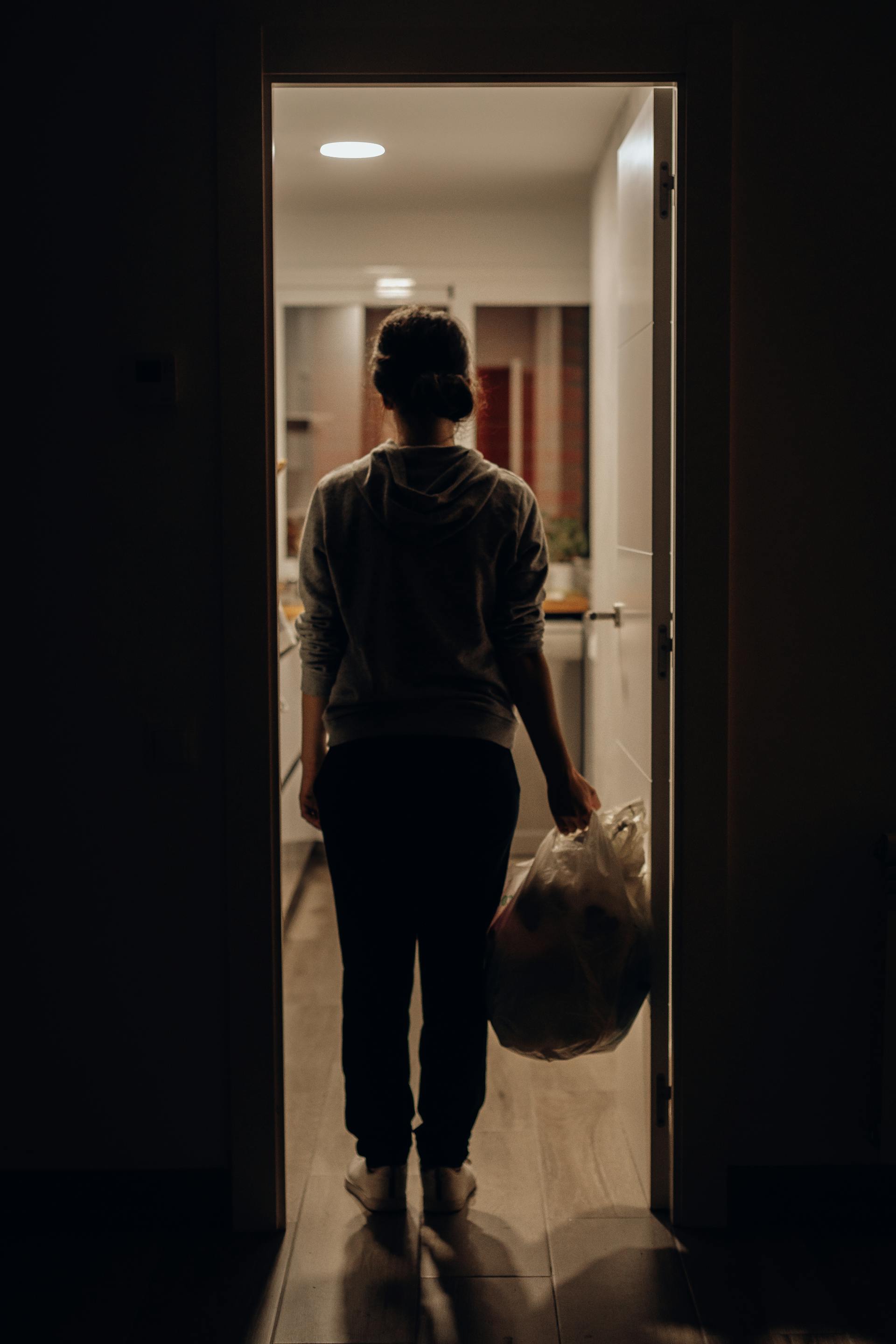 Una mujer sujetando una bolsa de basura | Fuente: Pexels