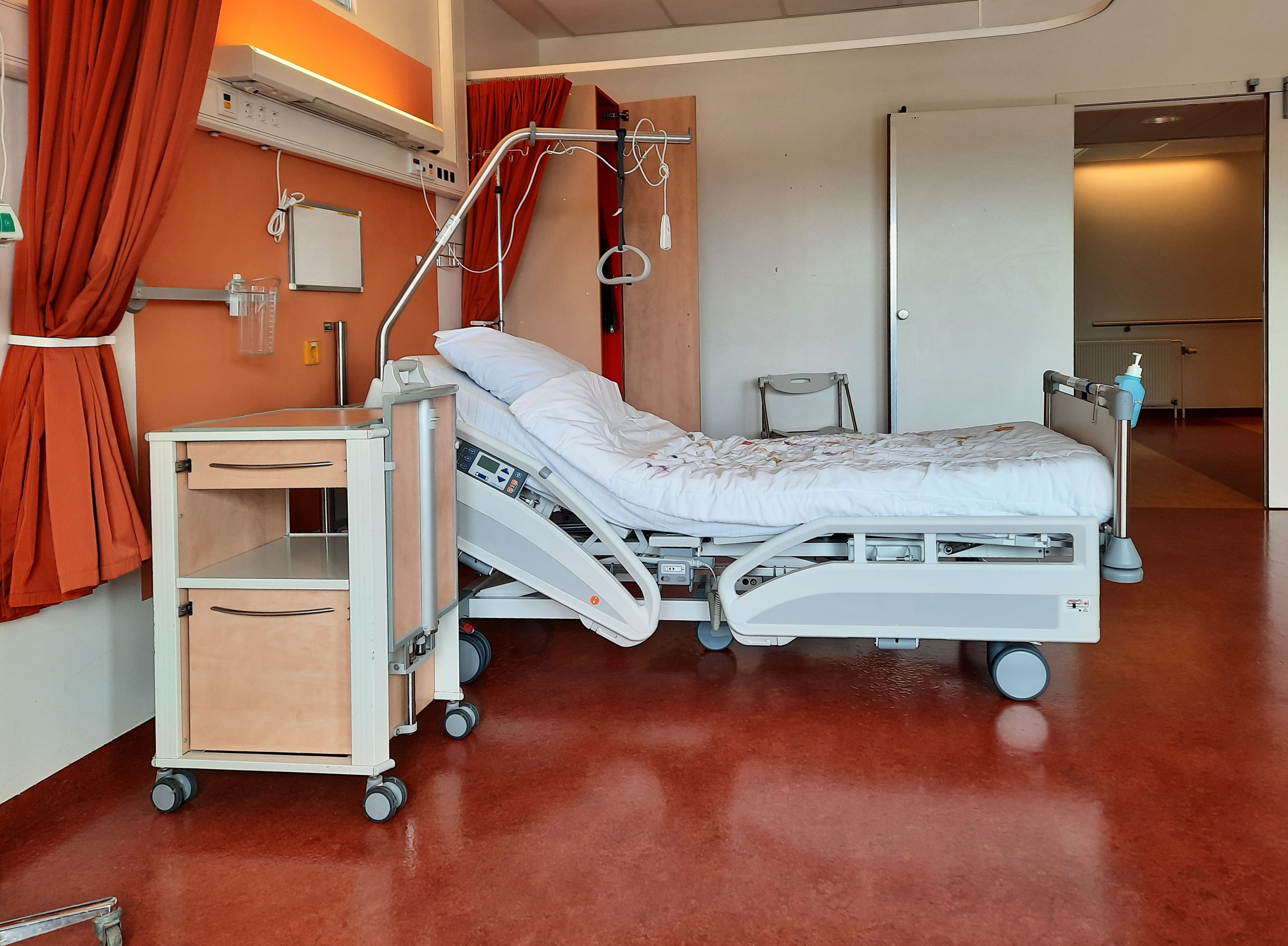 Una habitación de hospital limpia y moderna, equipada con una cama ajustable y material médico | Fuente: Pexels