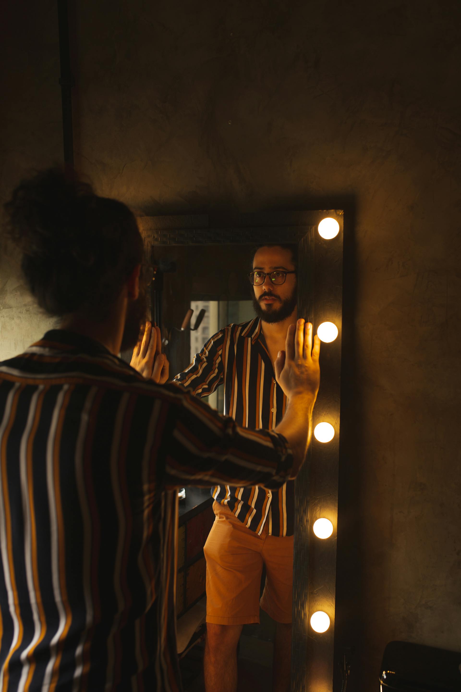 Un hombre mirando su reflejo en el espejo | Fuente: Pexels