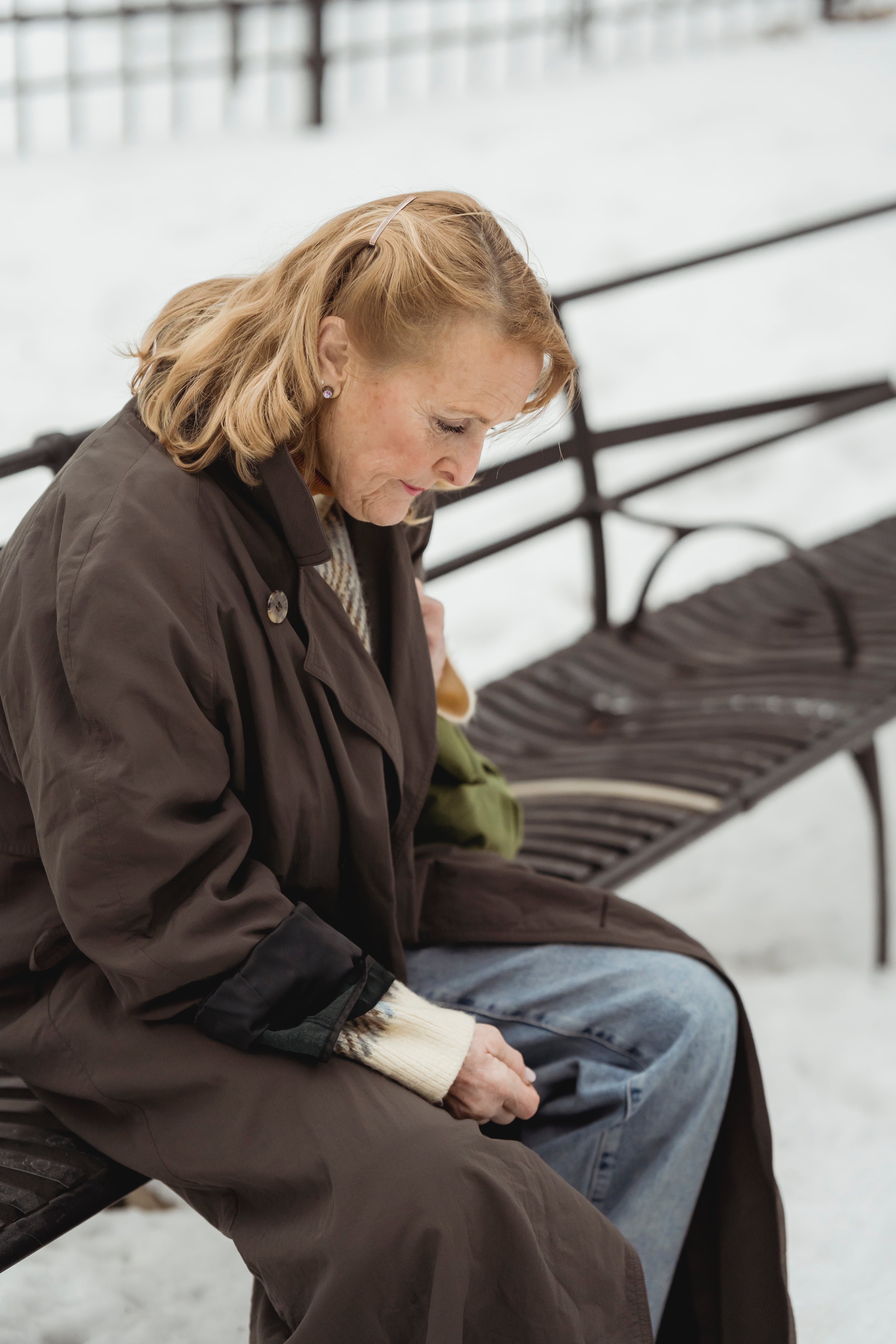 Una mujer mayor con aspecto deprimido sentada en un banco | Foto: Pexels