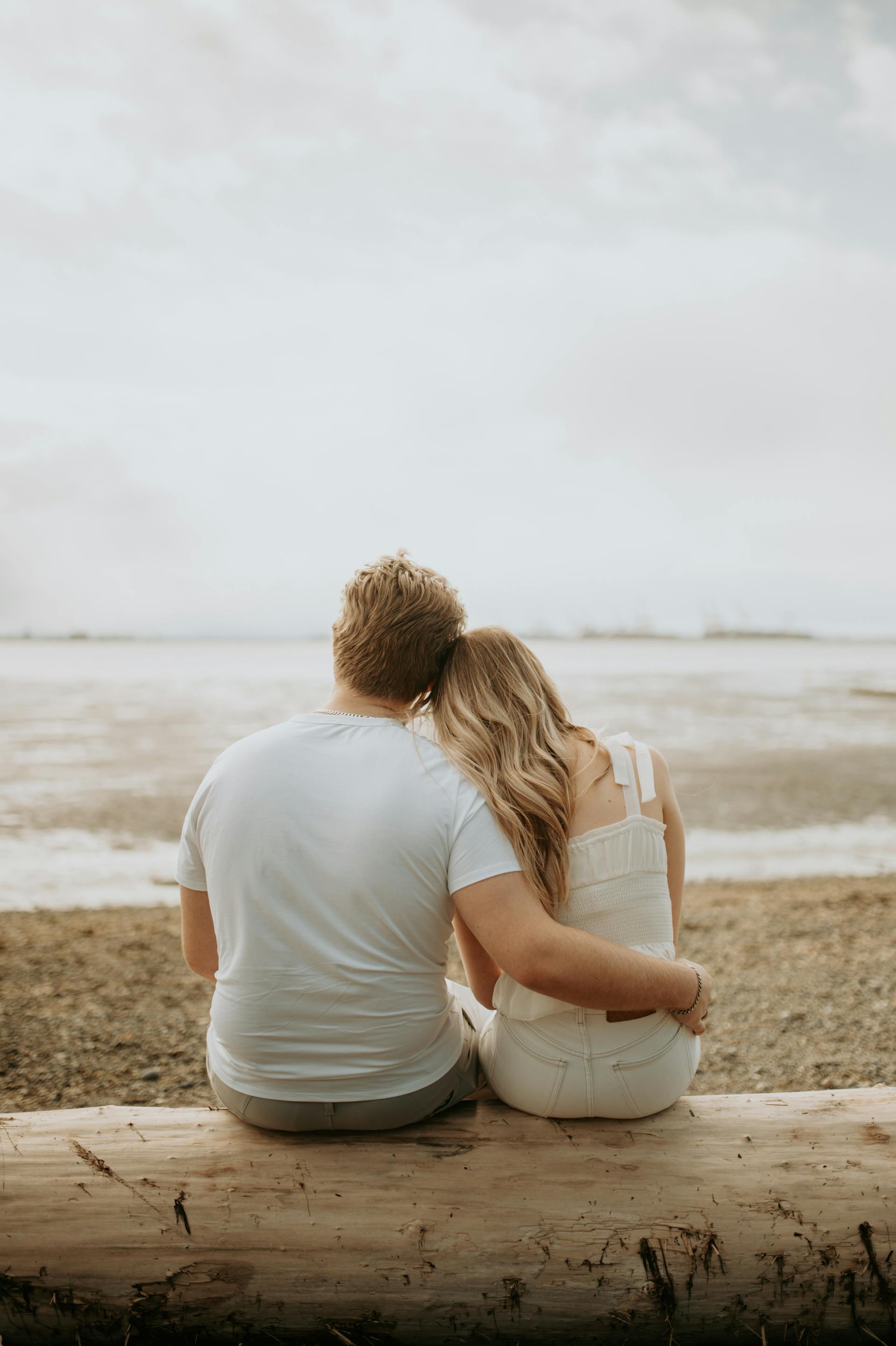 Vista trasera de una pareja sentada en una playa | Fuente: Pexels