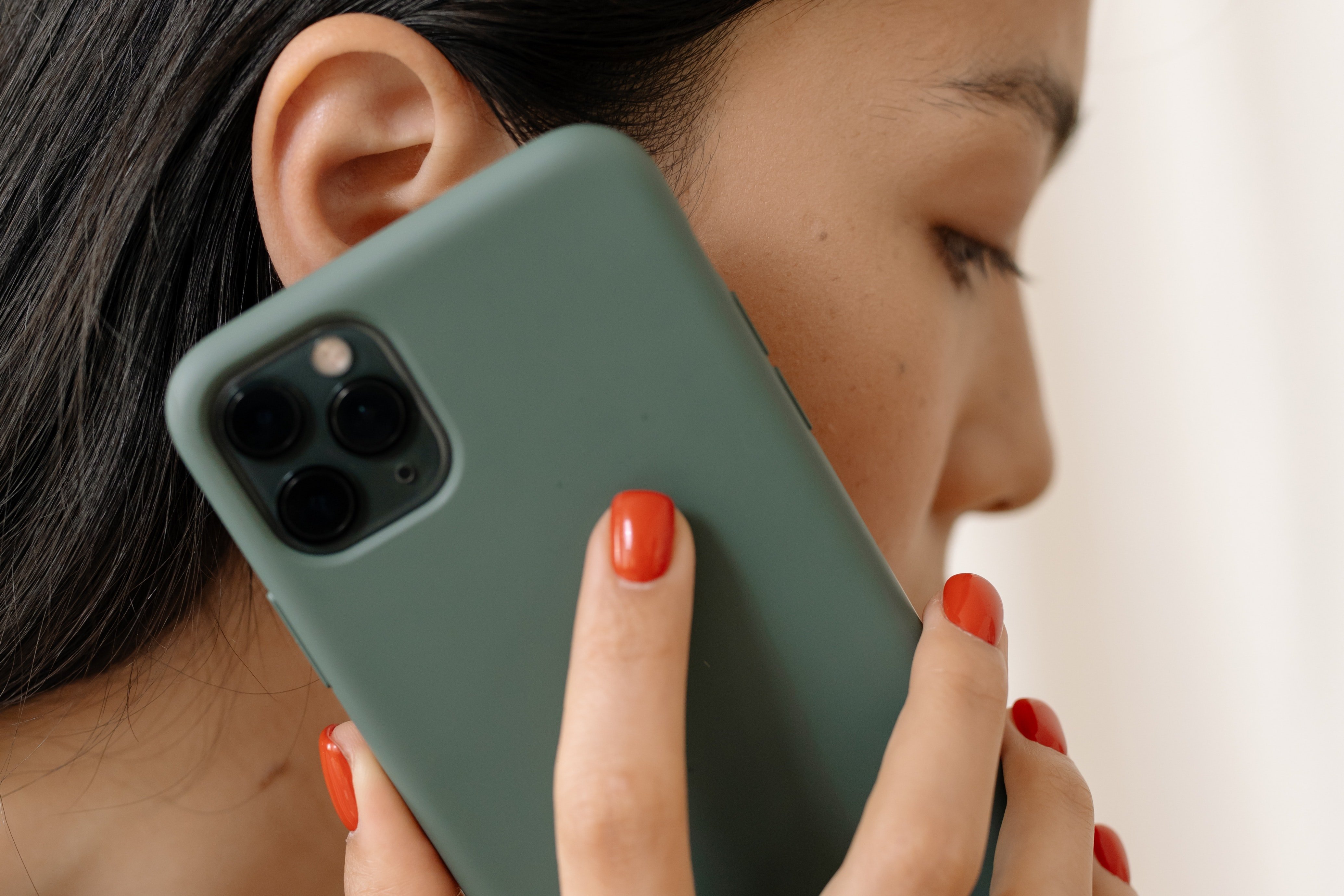 Mujer con un teléfono celular al oído. | Foto: Shutterstock