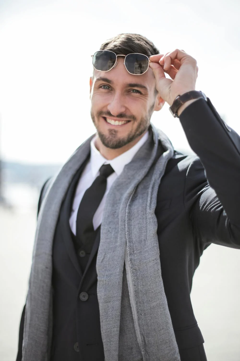 Un hombre sonriente quitándose las gafas de sol | Fuente: Pexels