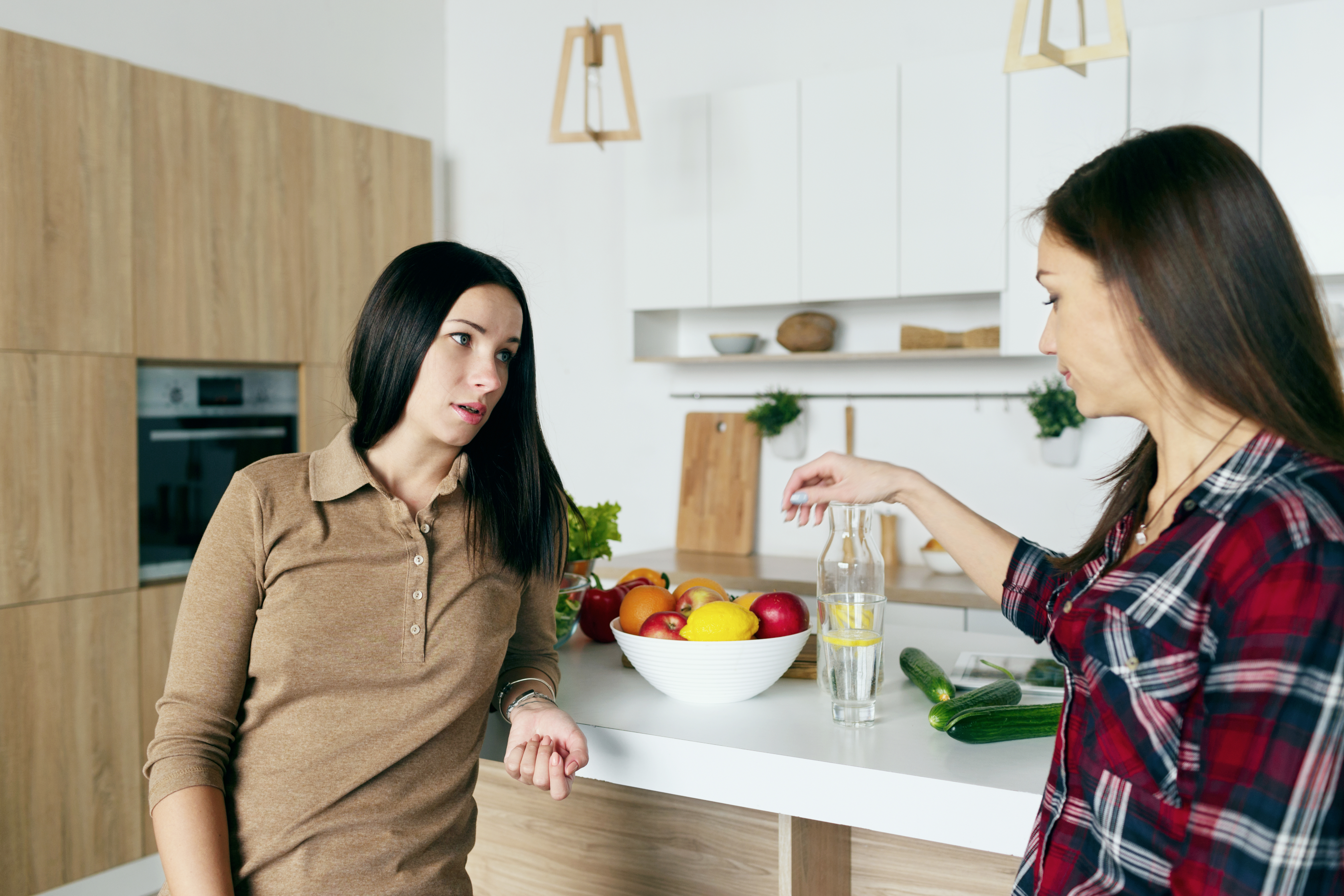 Dos mujeres hablando en la cocina | Fuente: Shutterstock
