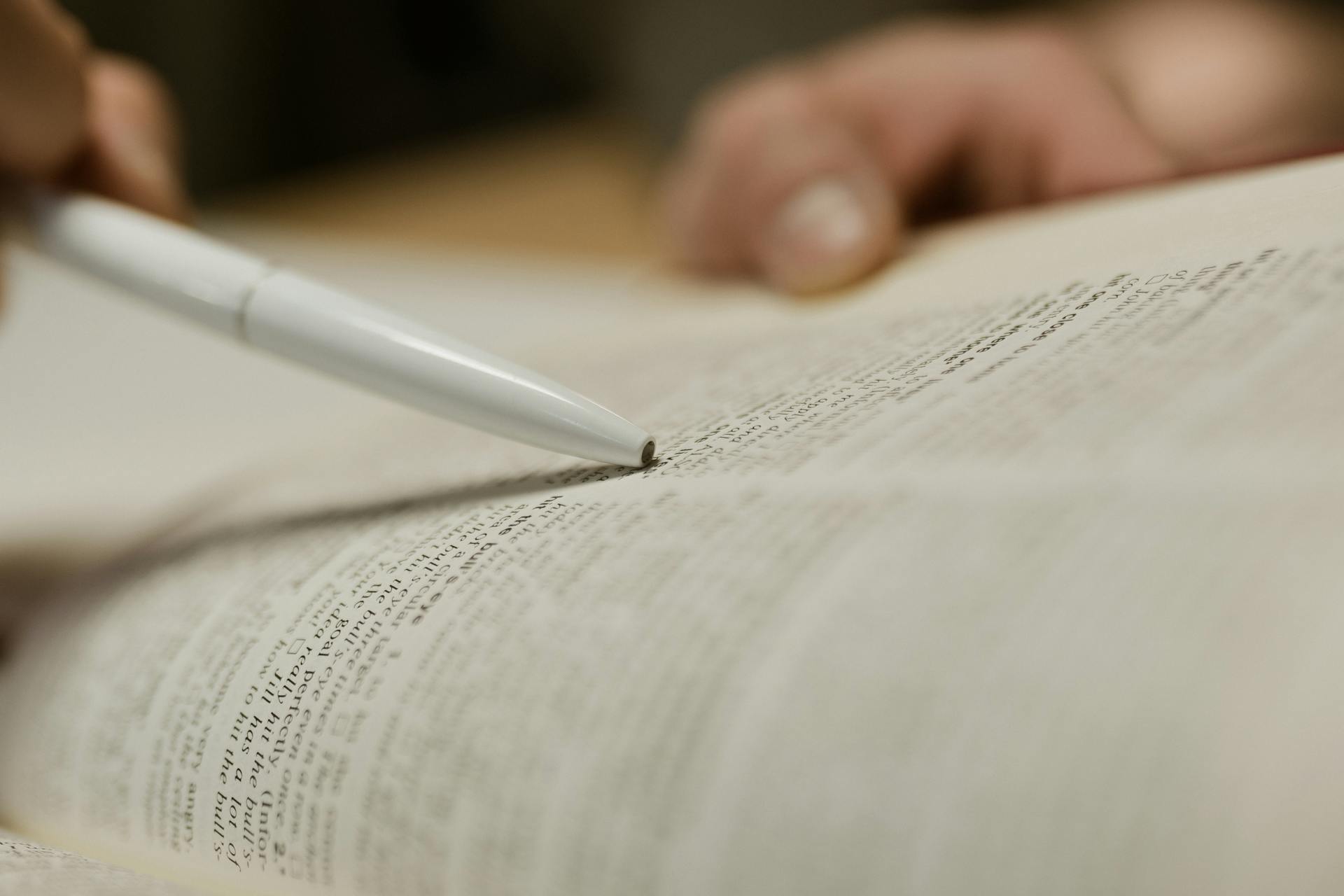 Una persona estudiando el texto de un libro | Fuente: Pexels