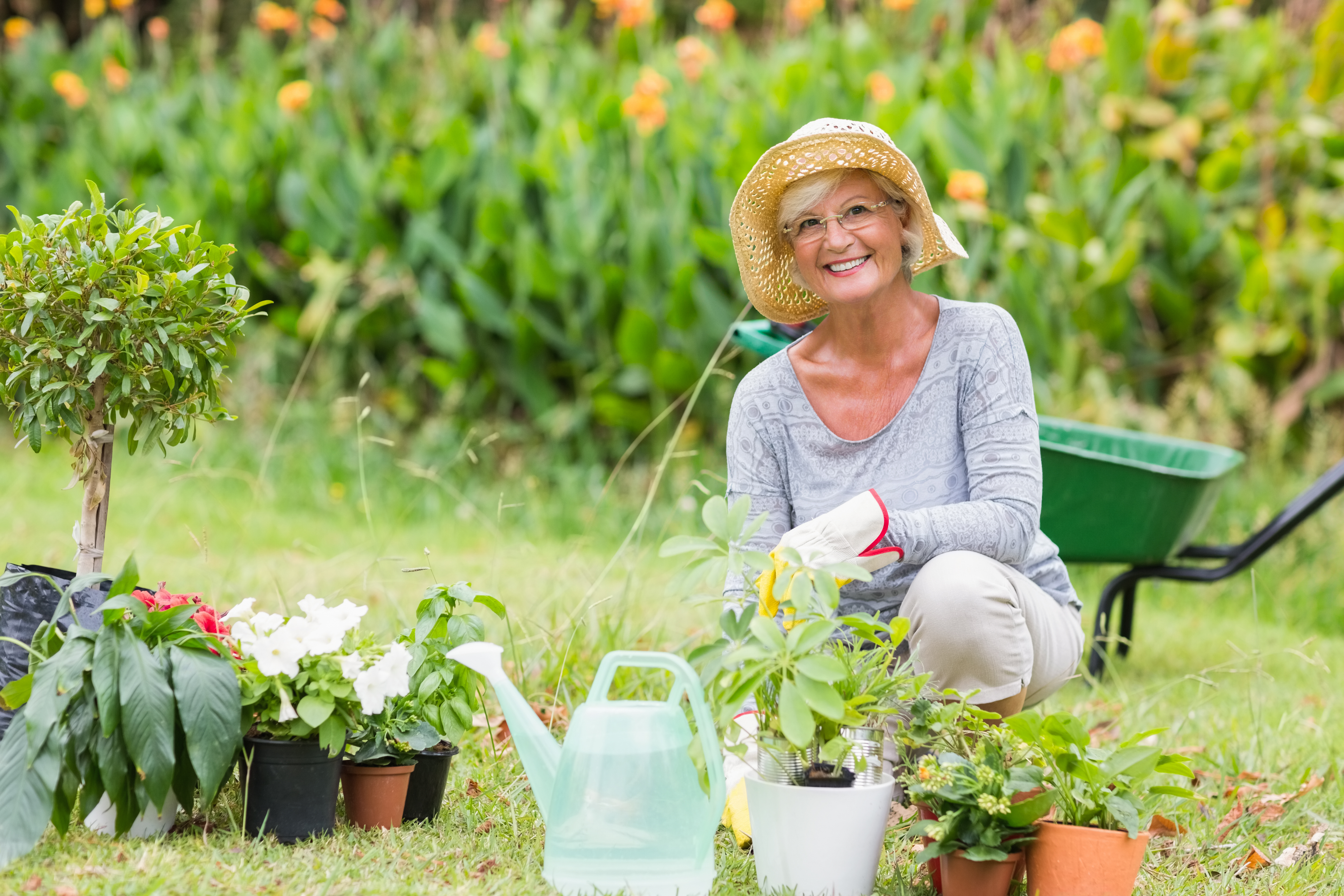 Una mujer mayor sonriente fotografiada mientras trabaja en el jardín | Fuente: Shutterstock
