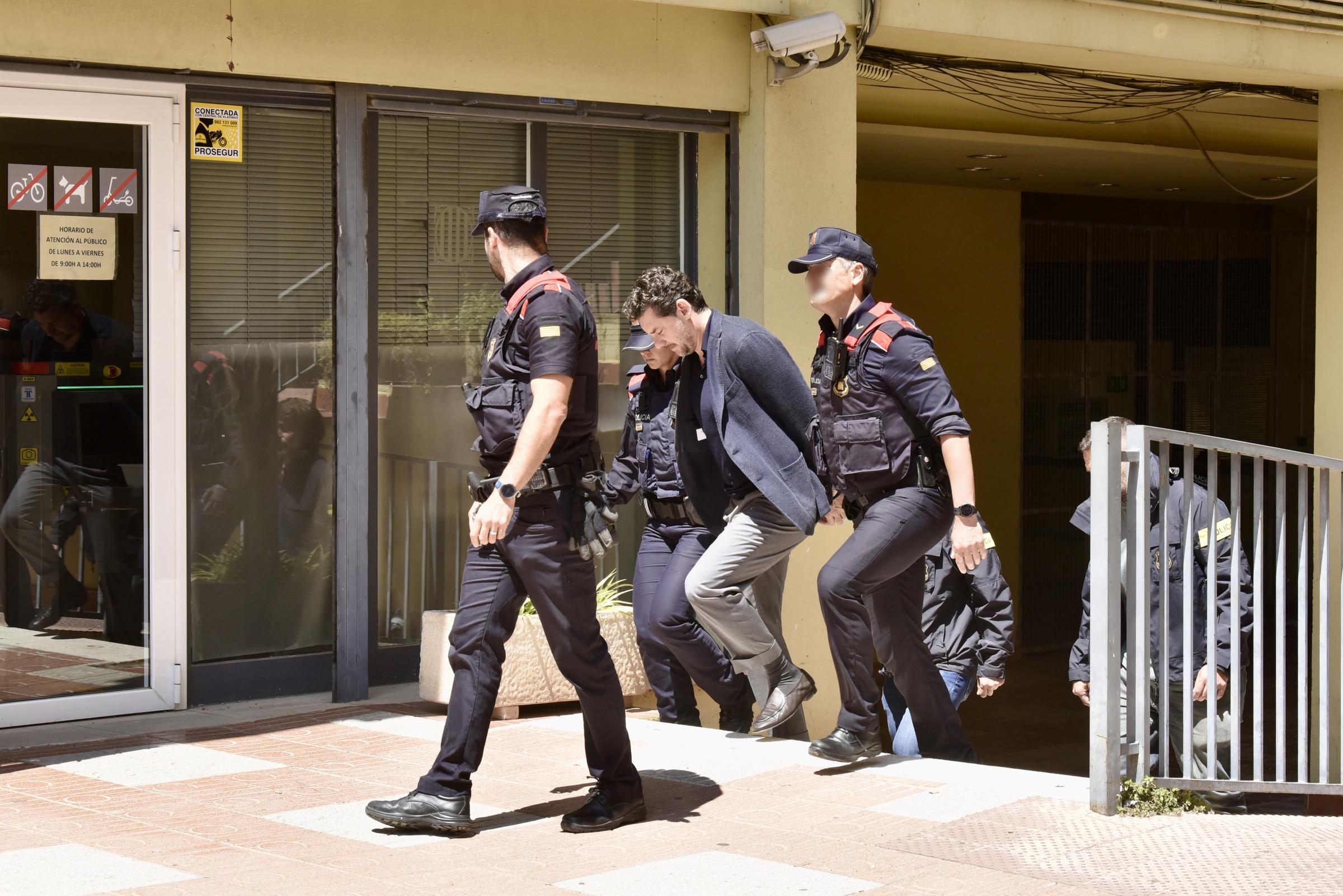 Agentes de la policía regional catalana (Mossos d'Esquadra) escoltan a Jonathan Andic, hijo de Isak Andic, fundador de la marca de moda española Mango, a su llegada a un juzgado en Martorell, cerca de Barcelona, ​​tras su detención el 19 de mayo de 2026. | Fuente: Getty Images