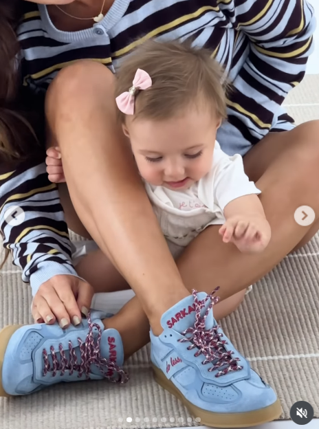Aitana descansó sentada sobre las piernas cruzadas de Camila mientras ambas compartían una escena relajada en el suelo del estudio. La imagen hace foco en el calzado urbano celeste con suela de goma caramelo y cordones trenzados que formó parte del lanzamiento. | Fuente: Instagram/camihoms