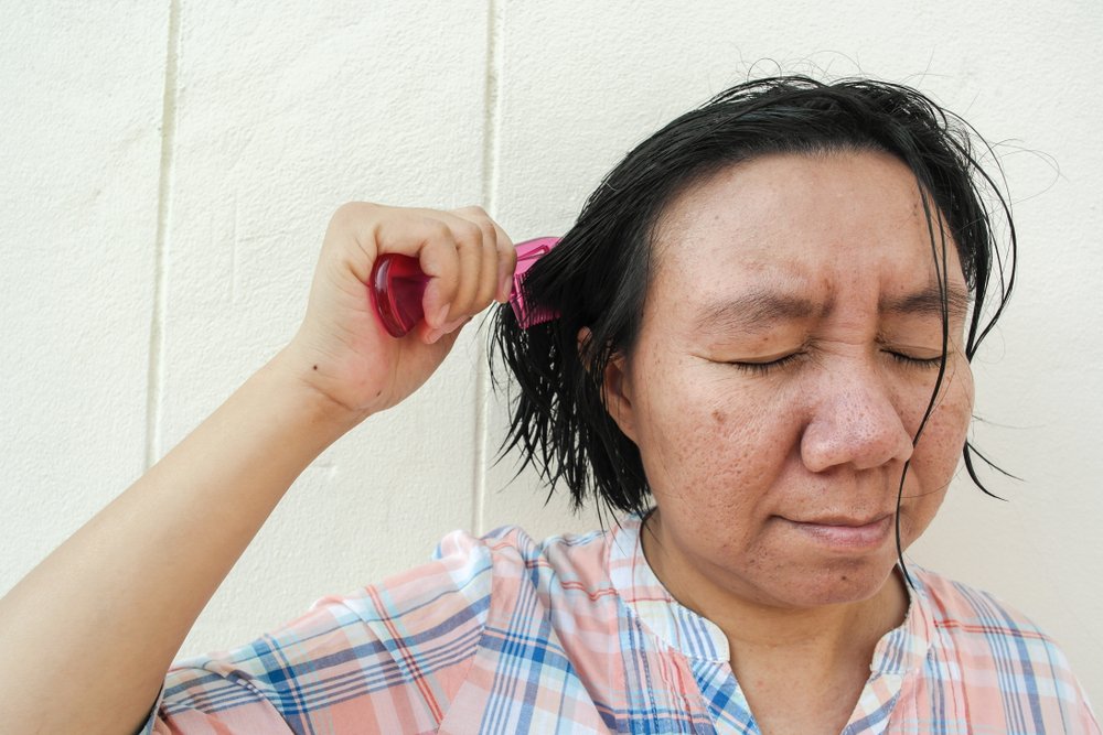 Mujer peinándose el cabello mojado en invierno. | Foto: Shutterstock