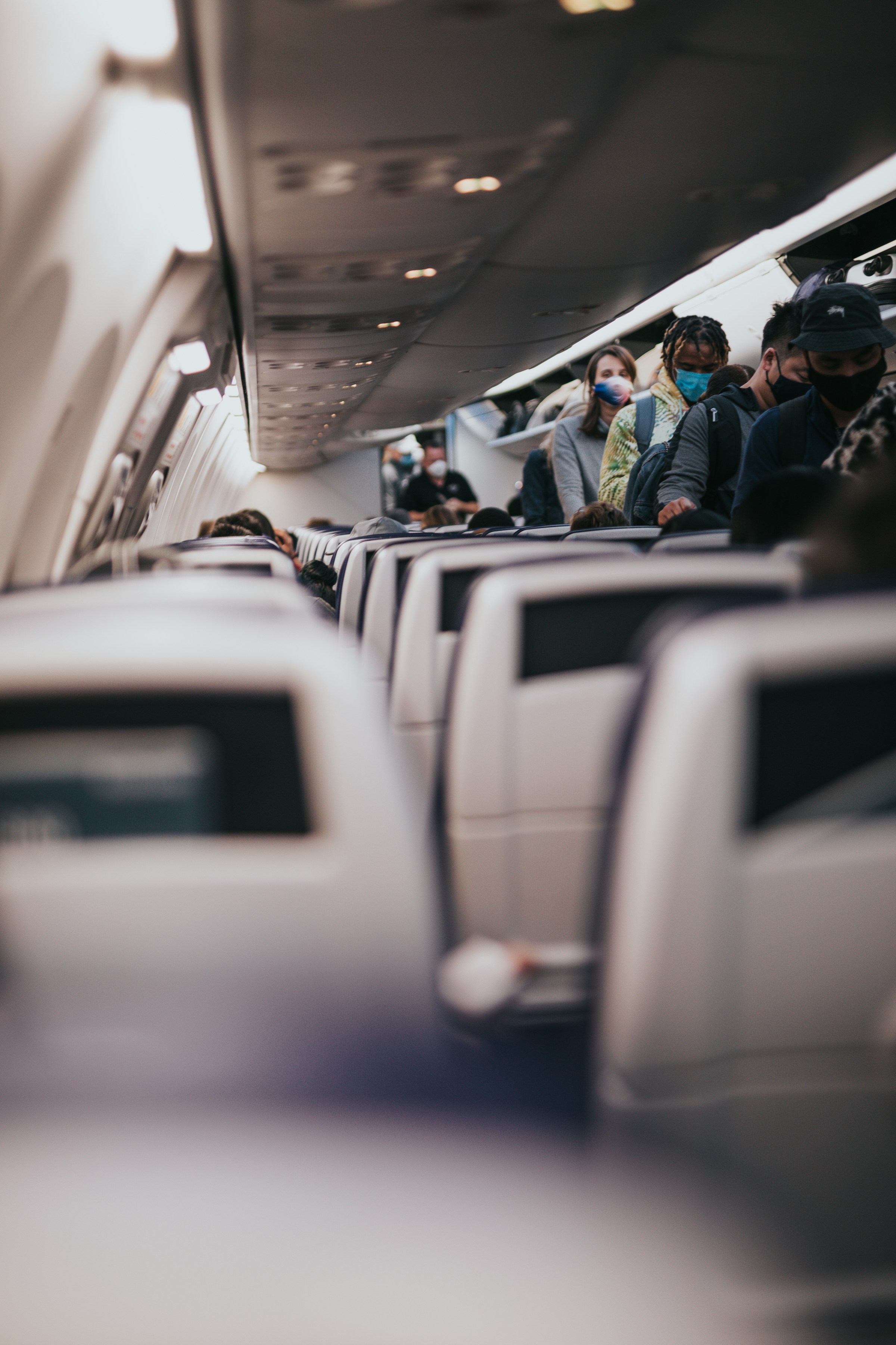 Gente ocupando sus asientos en un avión | Fuente: Unsplash