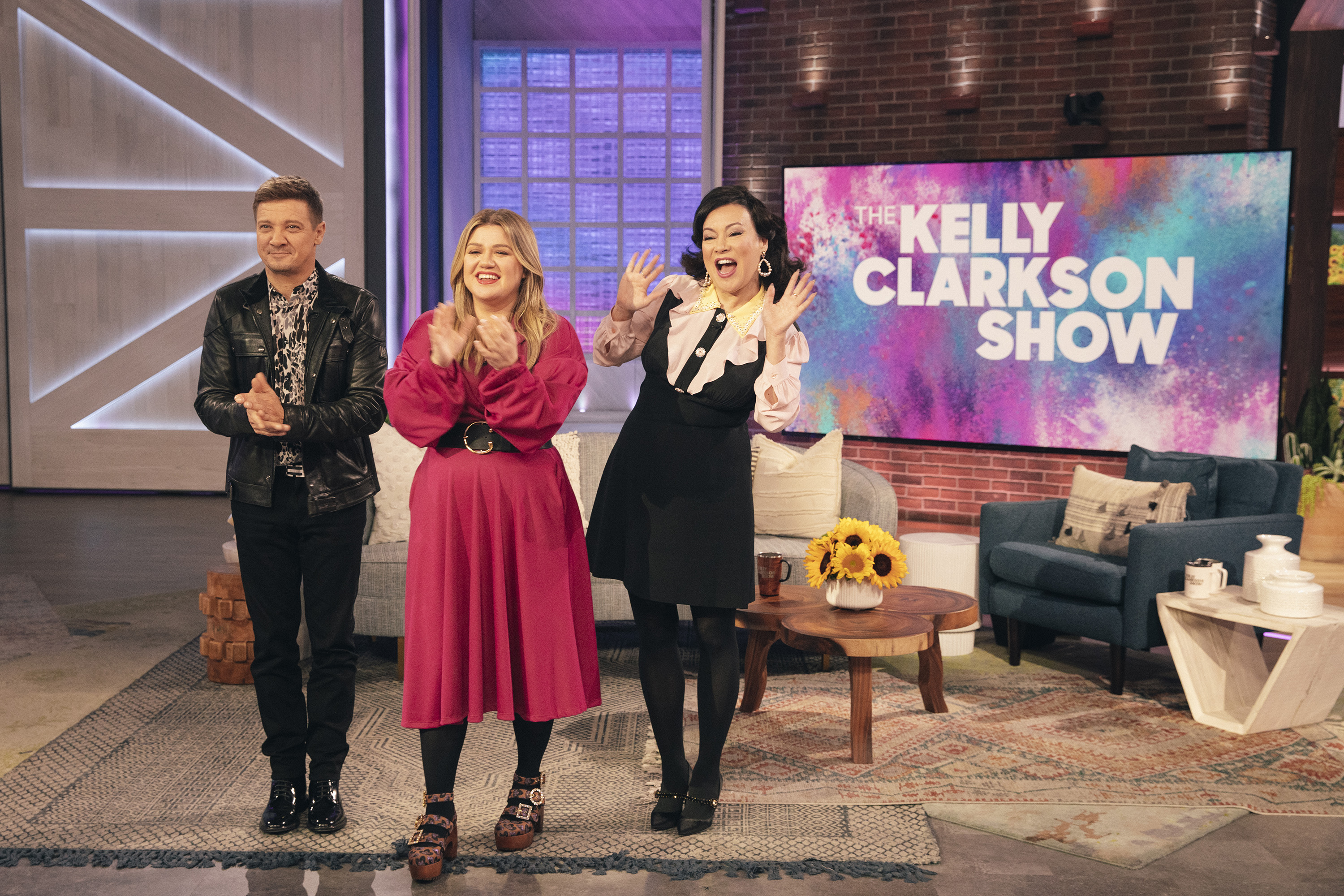Jeremy Renner, Kelly Clarkson y Jennifer Tilly en "The Kelly Clarkson Show" el 19 de noviembre de 2021 | Foto: Getty Images