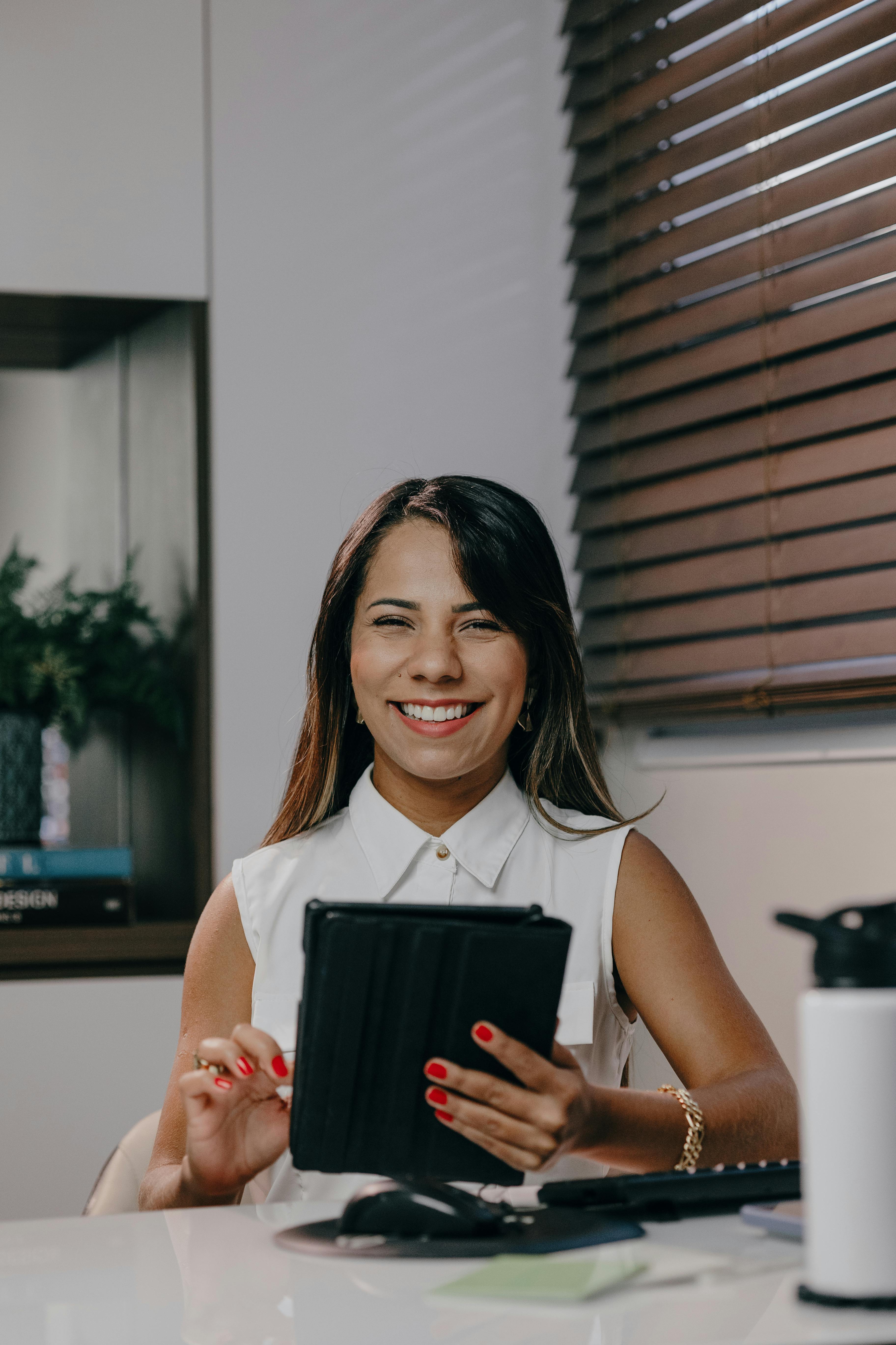 Una mujer sonriente en su lugar de trabajo | Fuente: Pexels