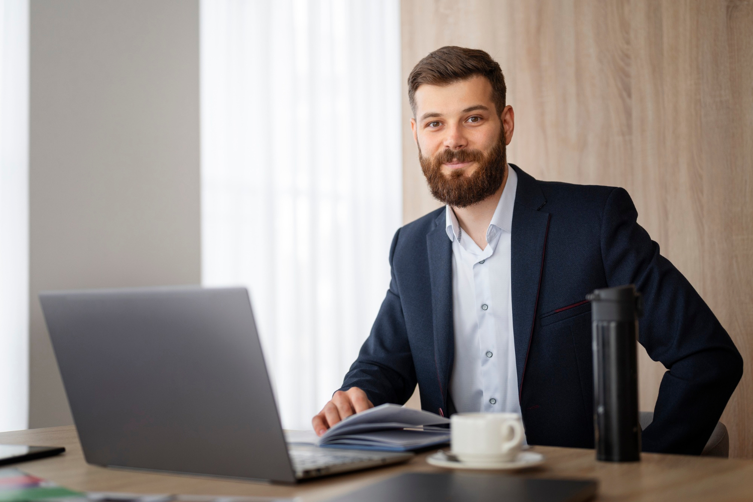 Un elegante hombre de negocios sentado en su despacho | Fuente: Freepik