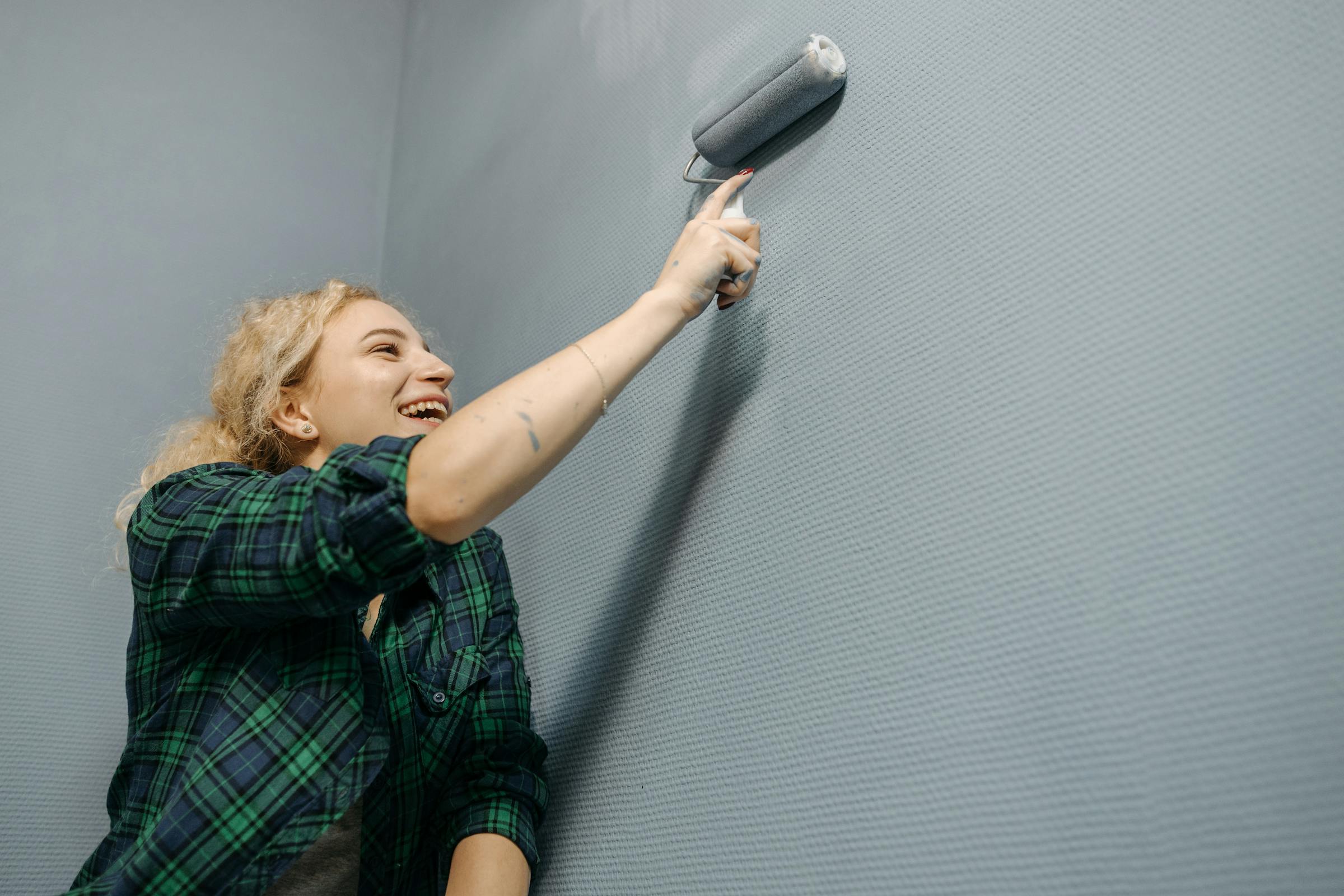 Una mujer pintando una pared | Fuente: Pexels