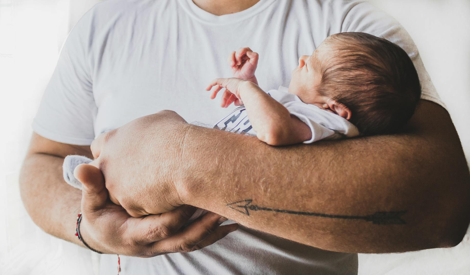 Un hombre con un bebé recién nacido en brazos | Fuente: Pexels