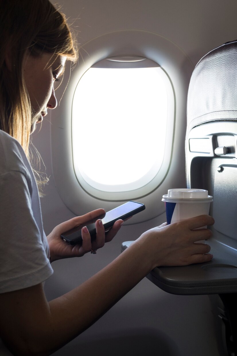 Una mujer mirando su teléfono en un avión | Fuente: Pexels