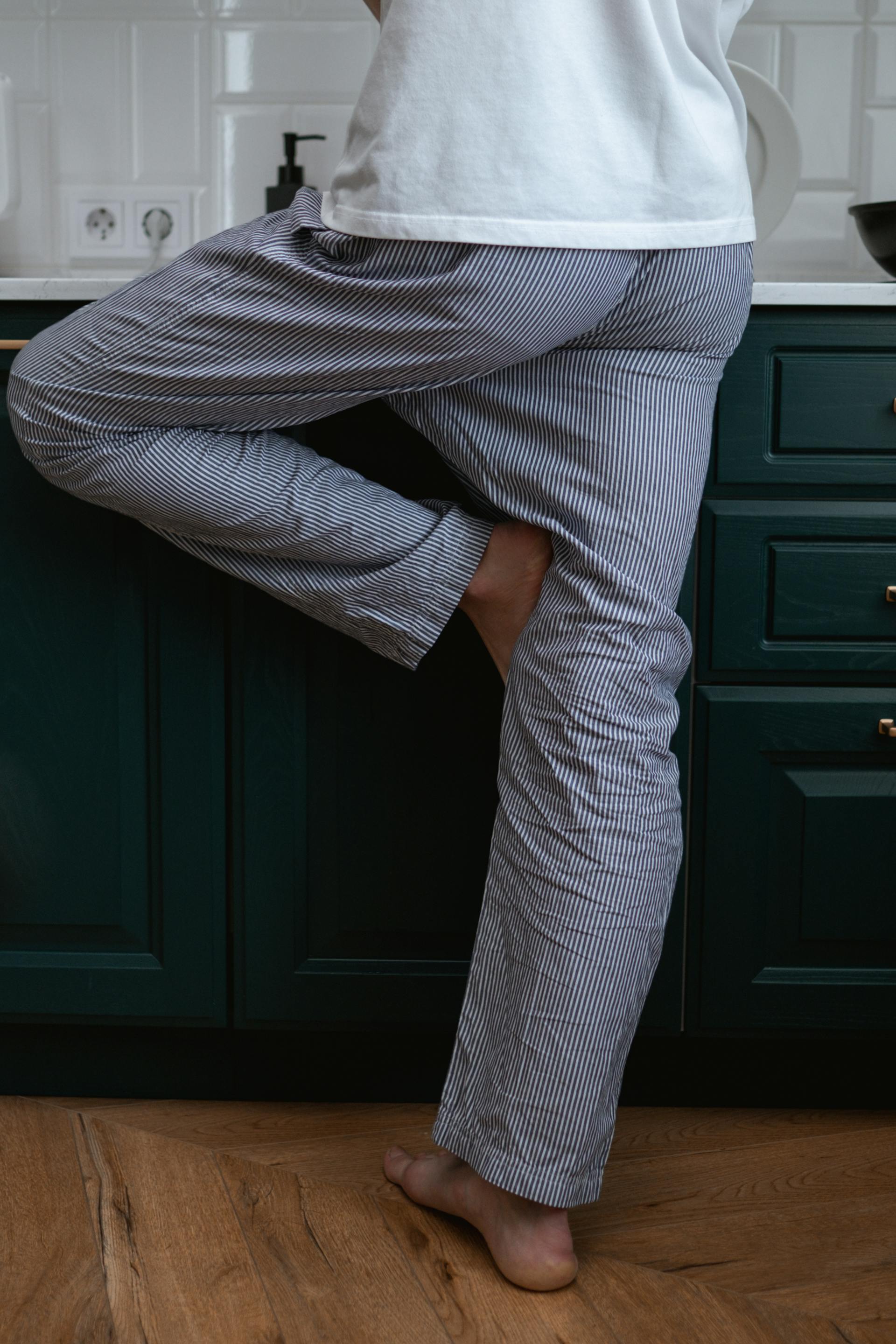 Un hombre de pie en una cocina en pijama | Fuente: Pexels