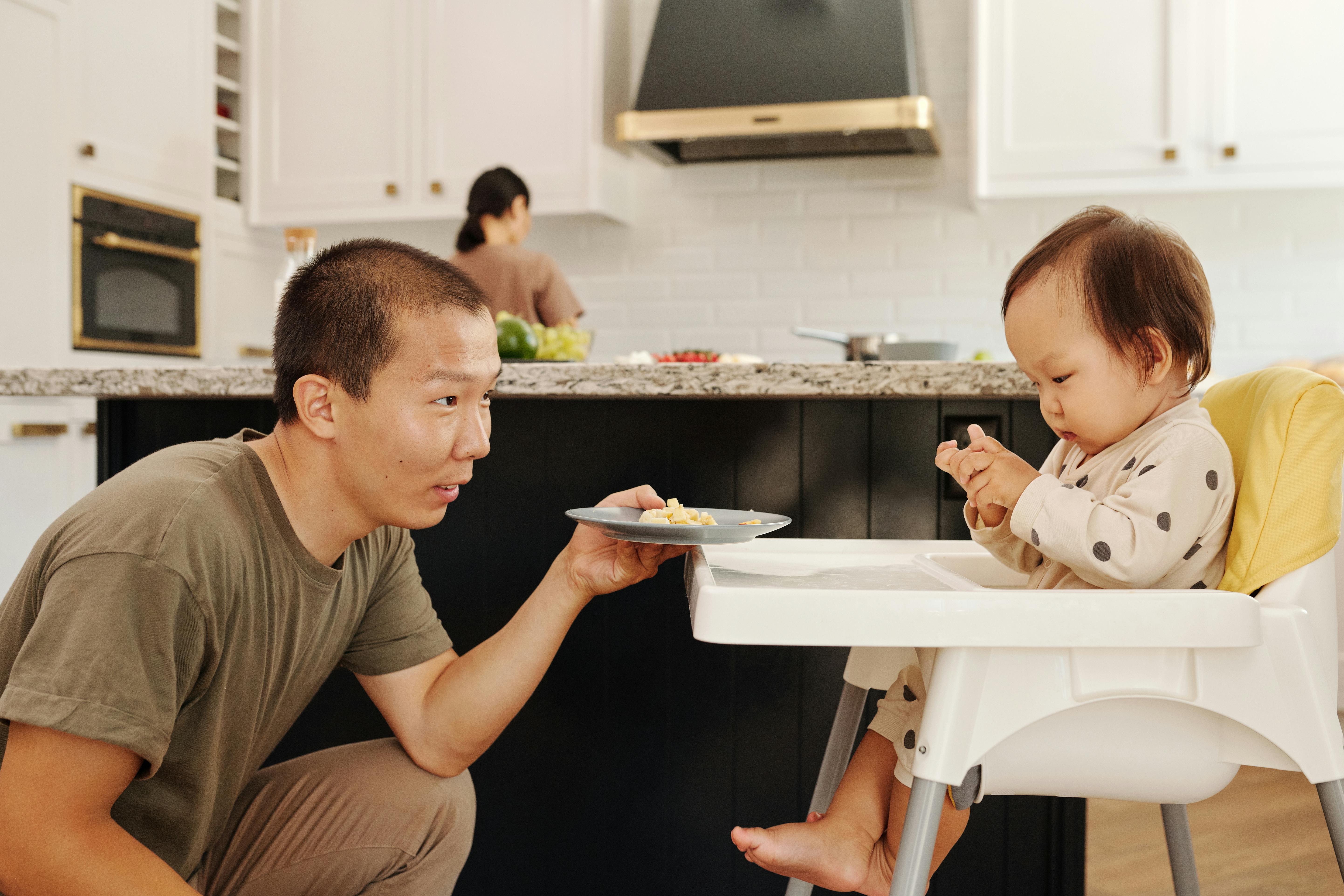 Papá dando de comer a su bebé | Fuente: Pexels