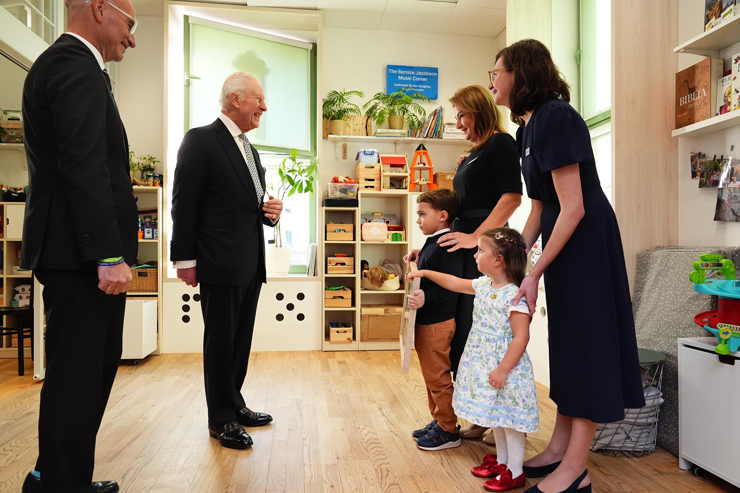 El rey Charles III recibe un cuadro de unos niños agradeciéndole su visita al Centro Comunitario Judío | Fuente: Getty Images