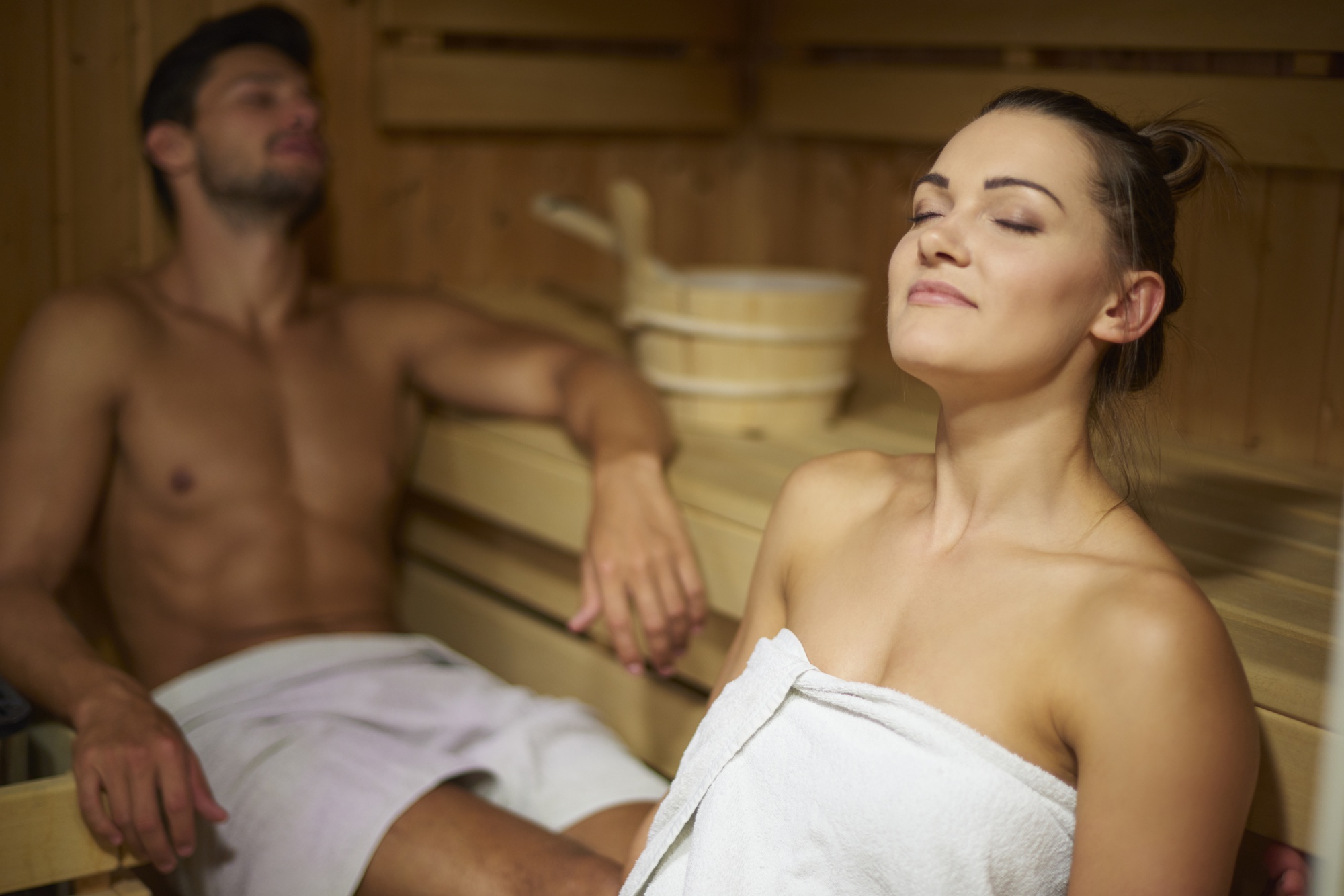 Un hombre y una mujer relajándose juntos en una sauna | Fuente: Freepik