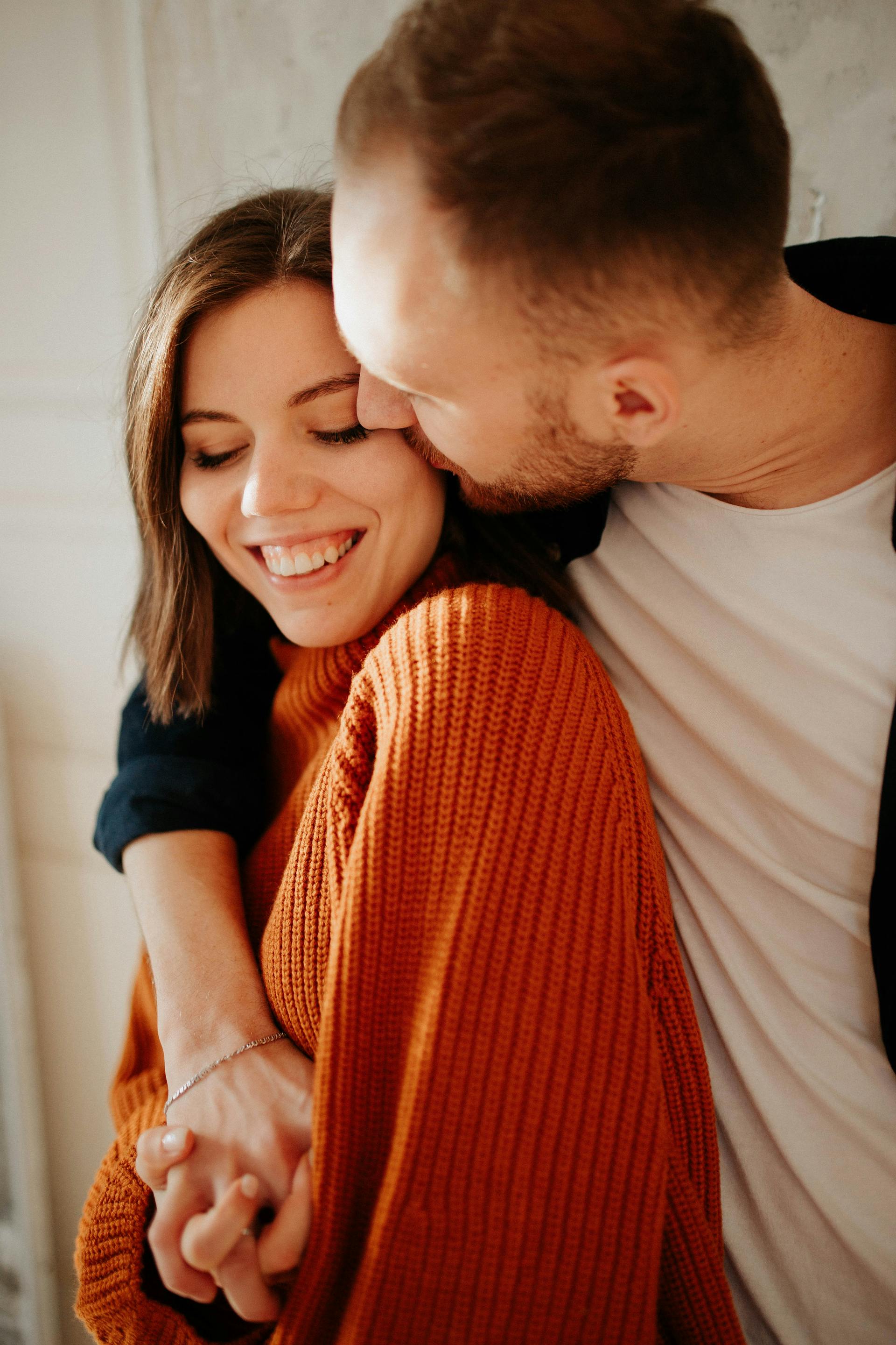 Un hombre besando y abrazando a su mujer | Fuente: Pexels