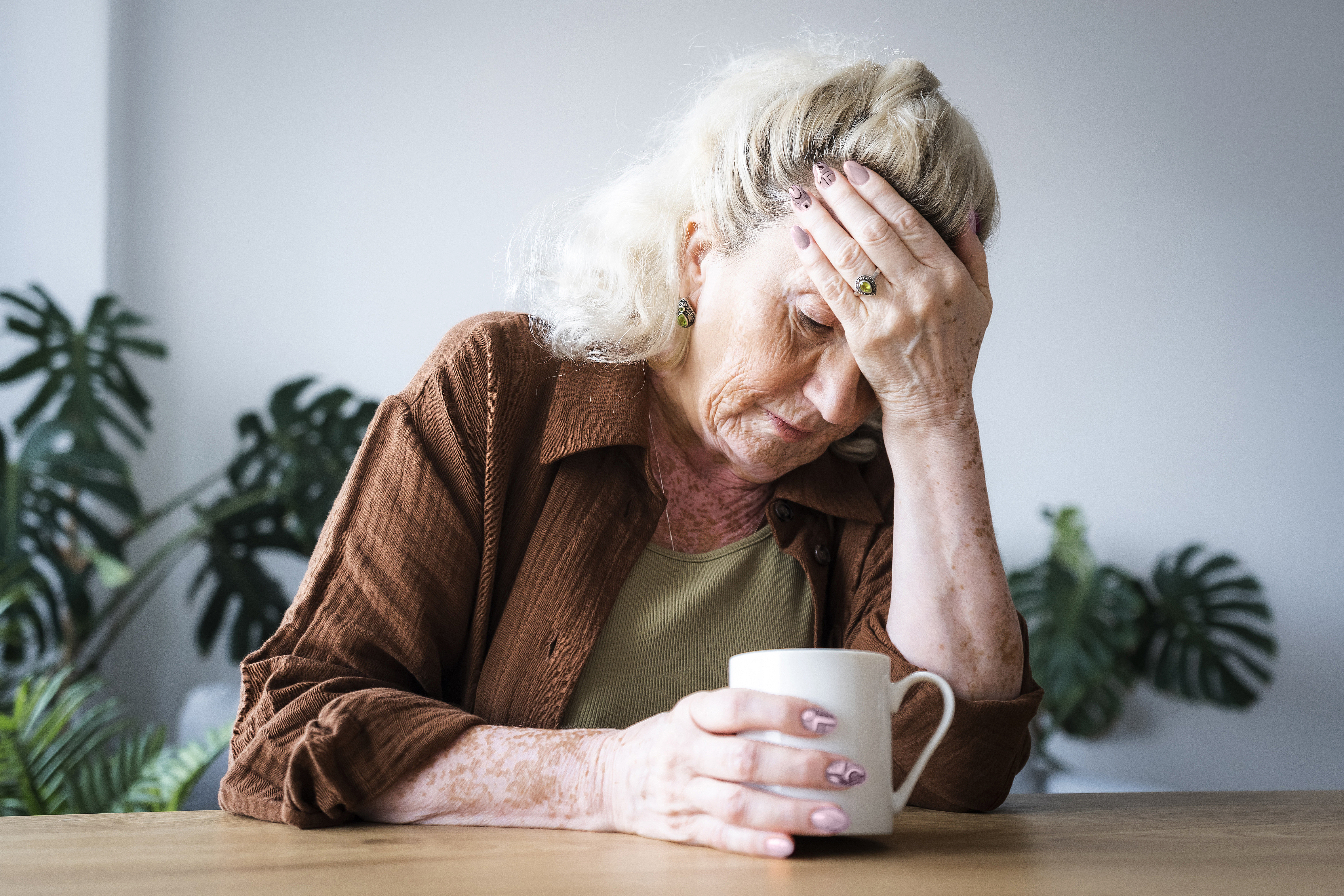 Mujer mayor disgustada sentada con una taza | Fuente: Getty Images