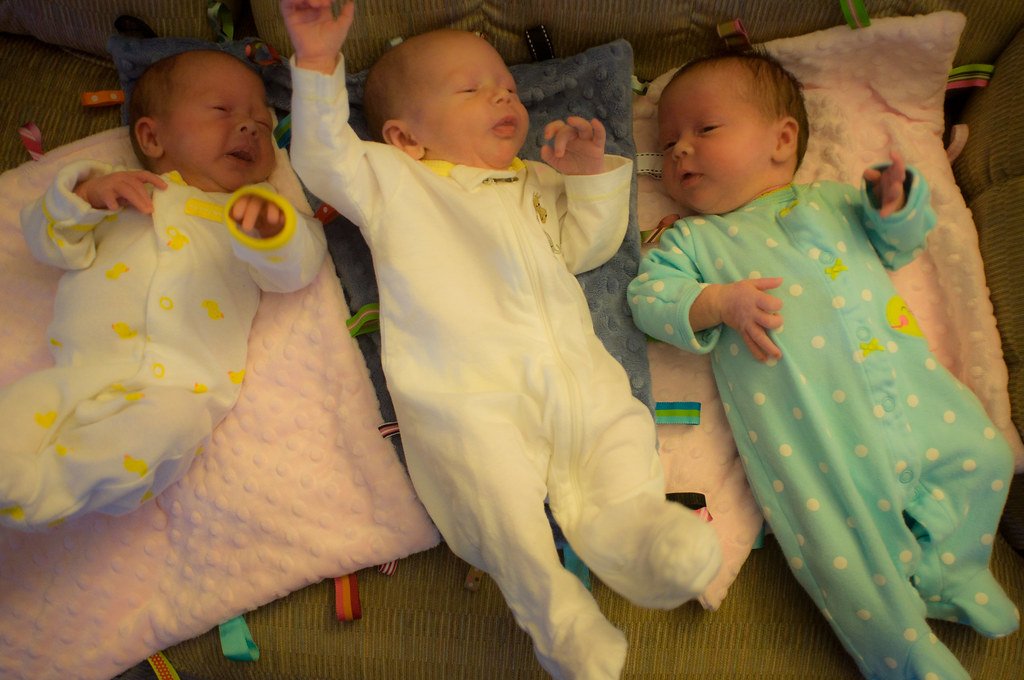 Trillizos recién nacidos reposan en una cama. | Foto: Flickr
